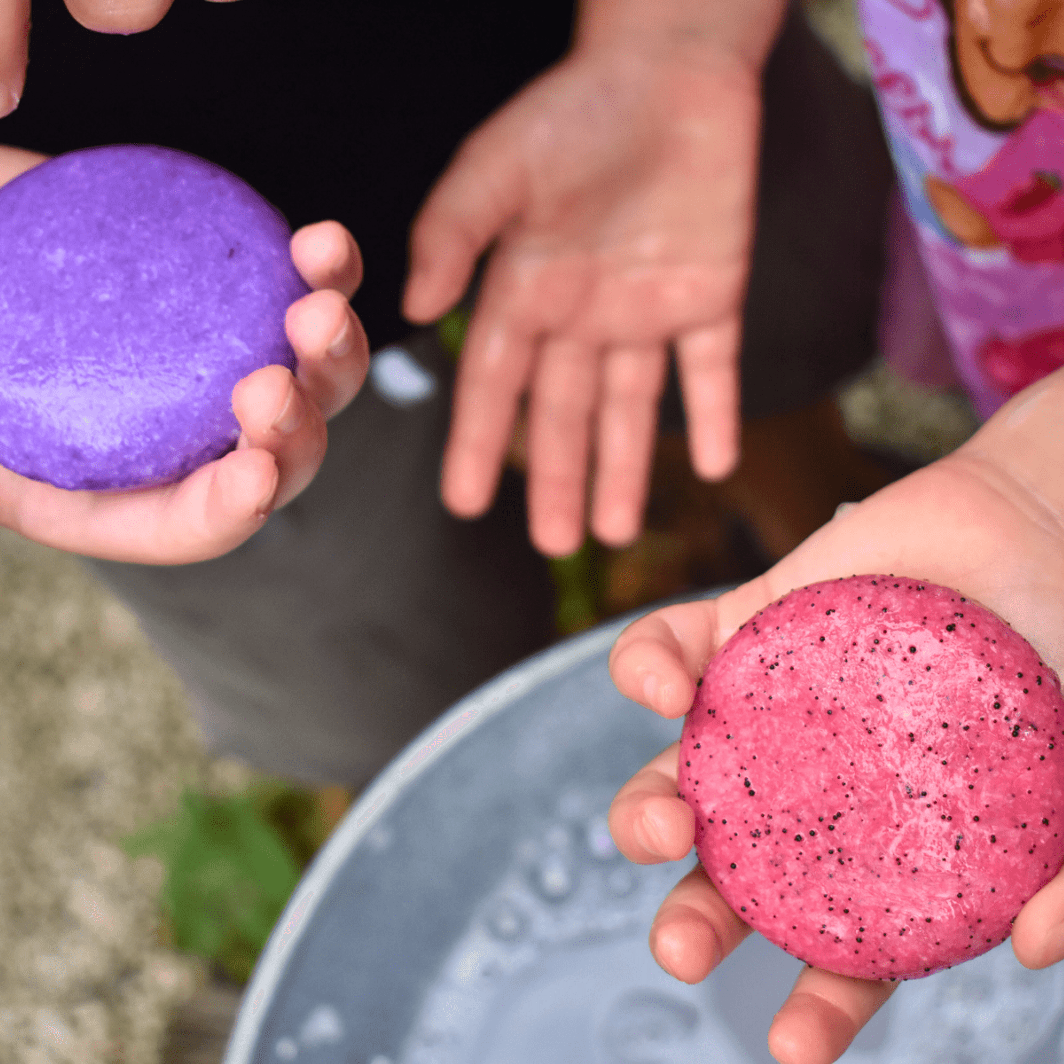 Kids shampoo bar, pink watermelon-scented, held in hands