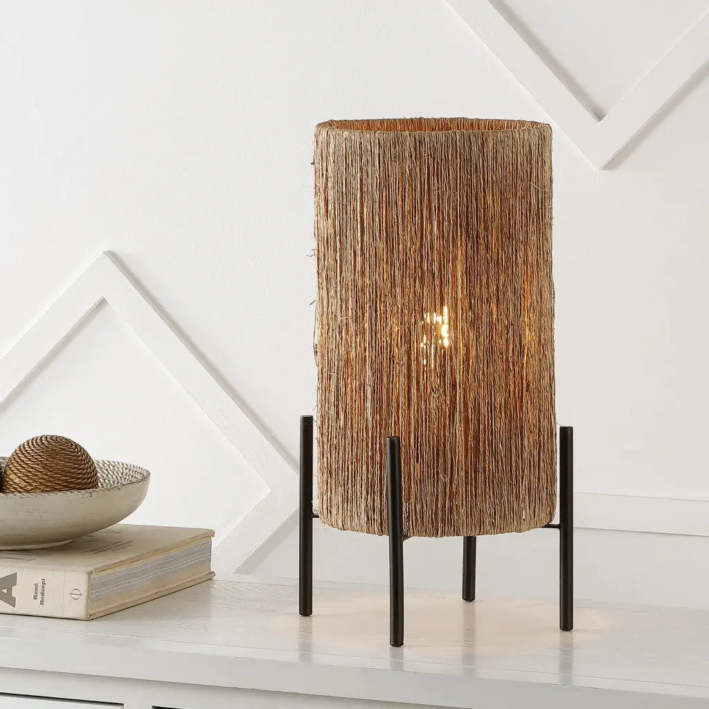 Natural woven straw table lamp with black metal legs, creating a warm, contemporary look for modern home décor.