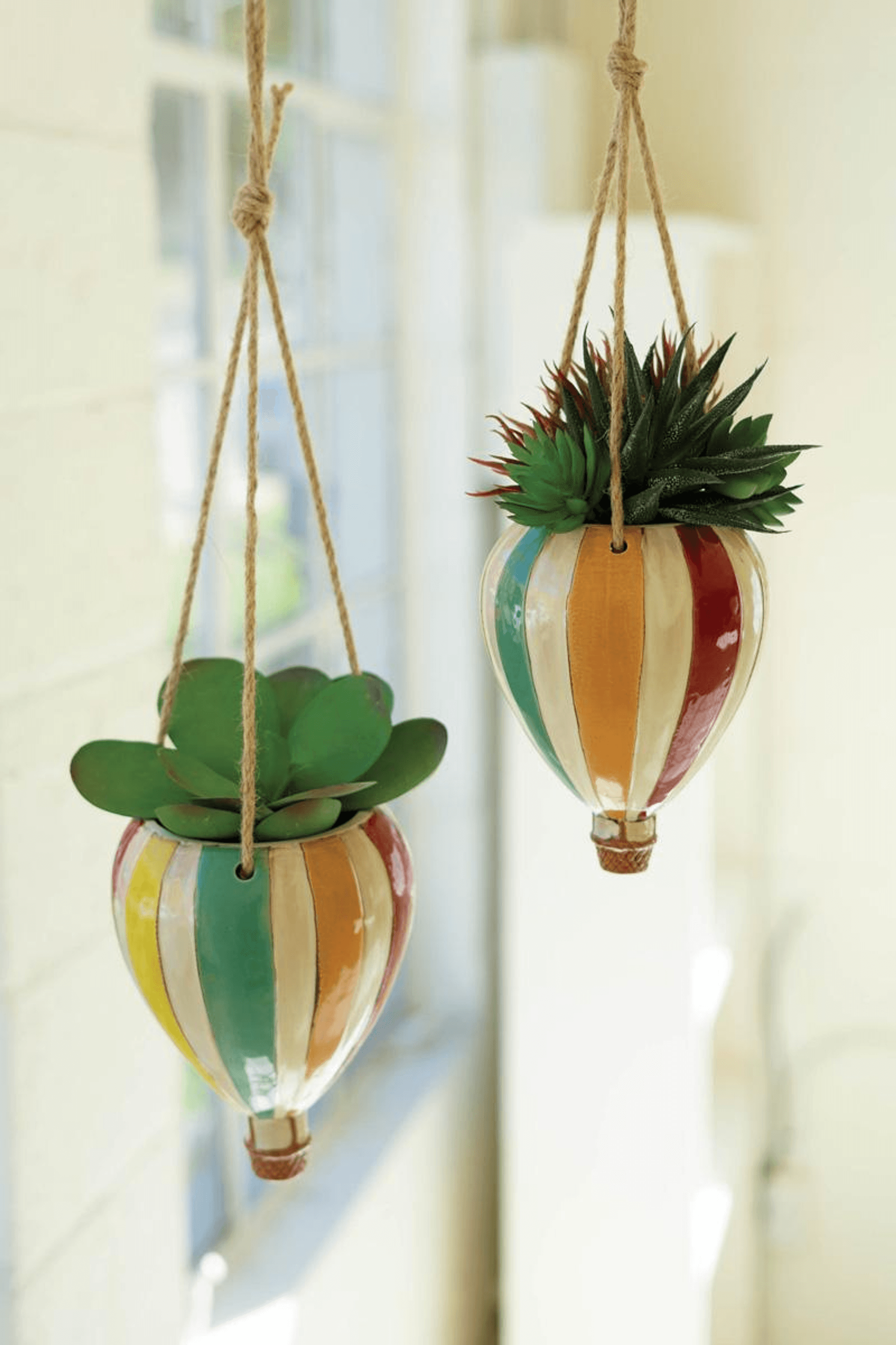 Set of two ceramic hot air balloon hanging planters with green succulents