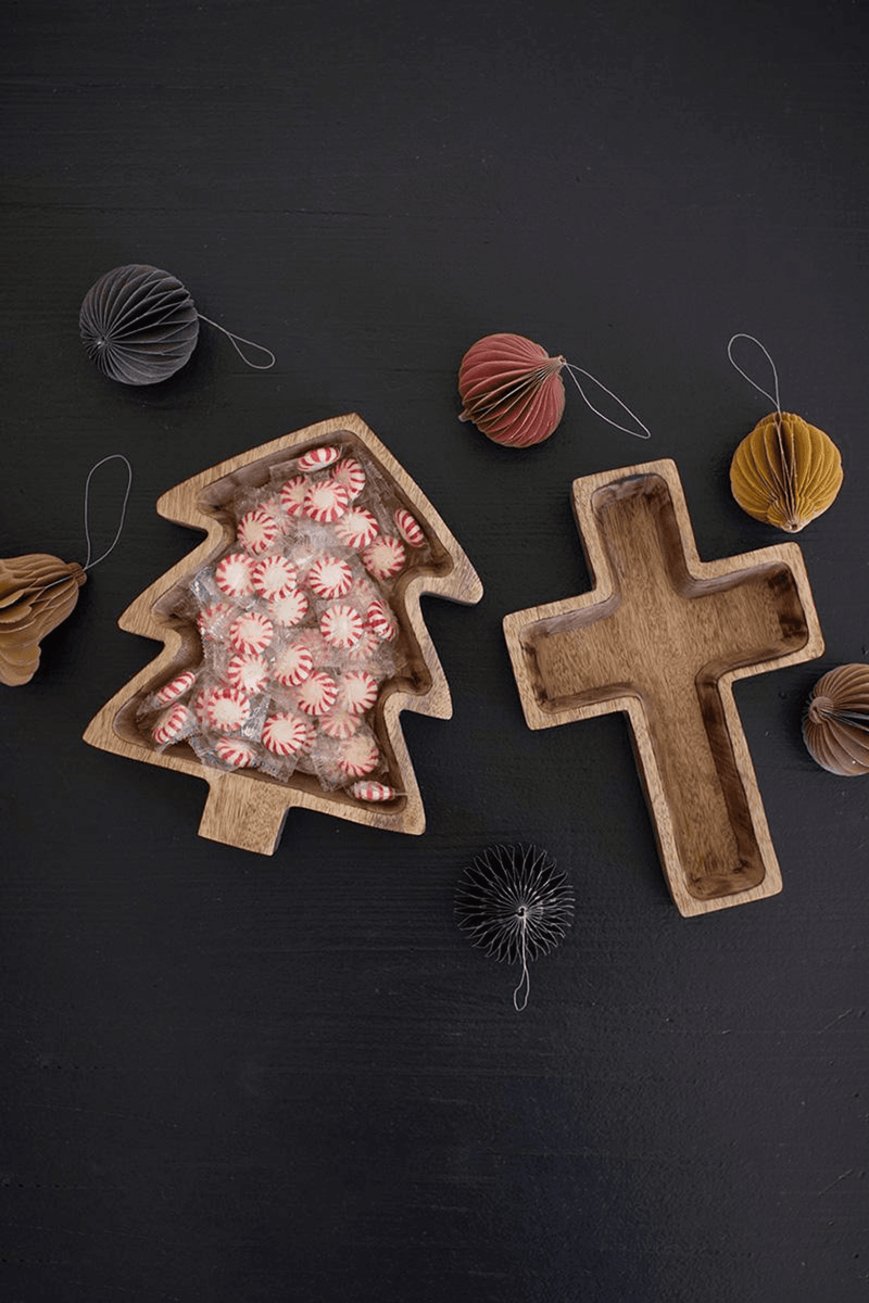 Wooden cross-shaped bowl with decorative twine ornaments nearby