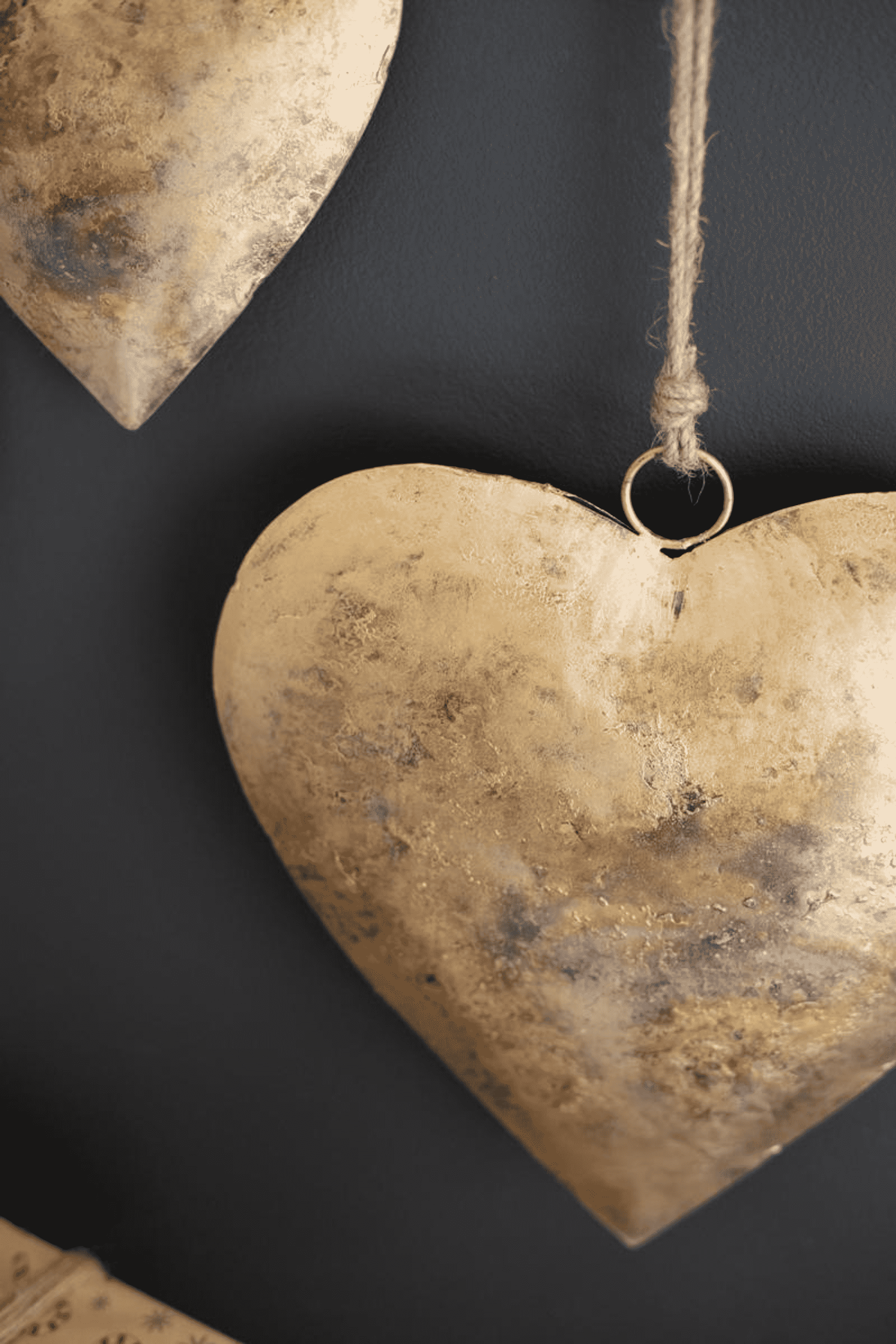 Antique gold heart door hanger with twine loop and distressed metal finish