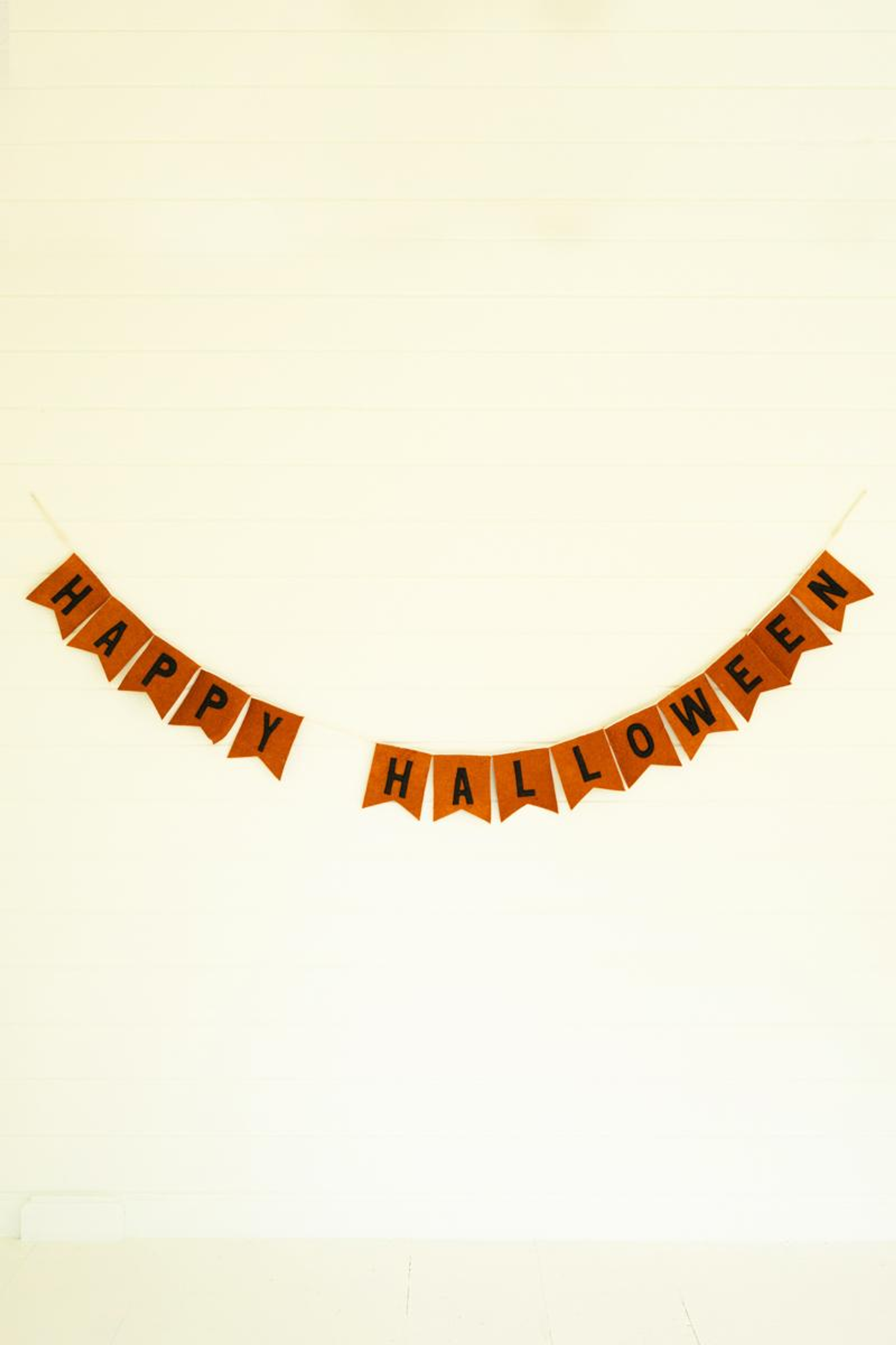 Orange felt Halloween garland with black 'HAPPY HALLOWEEN' letters