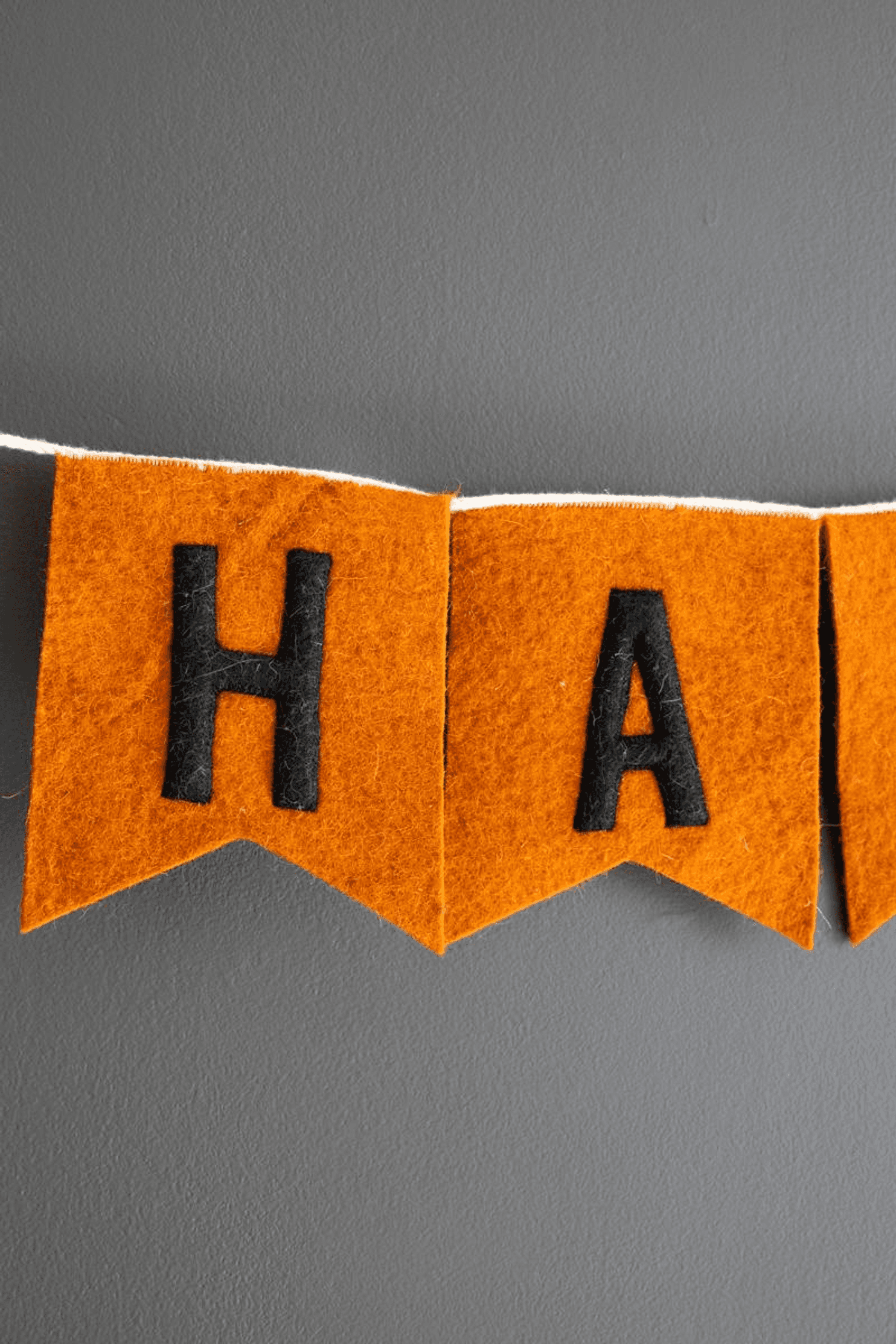 Orange felt garland banner with black letter 'HA' on cut corner flags
