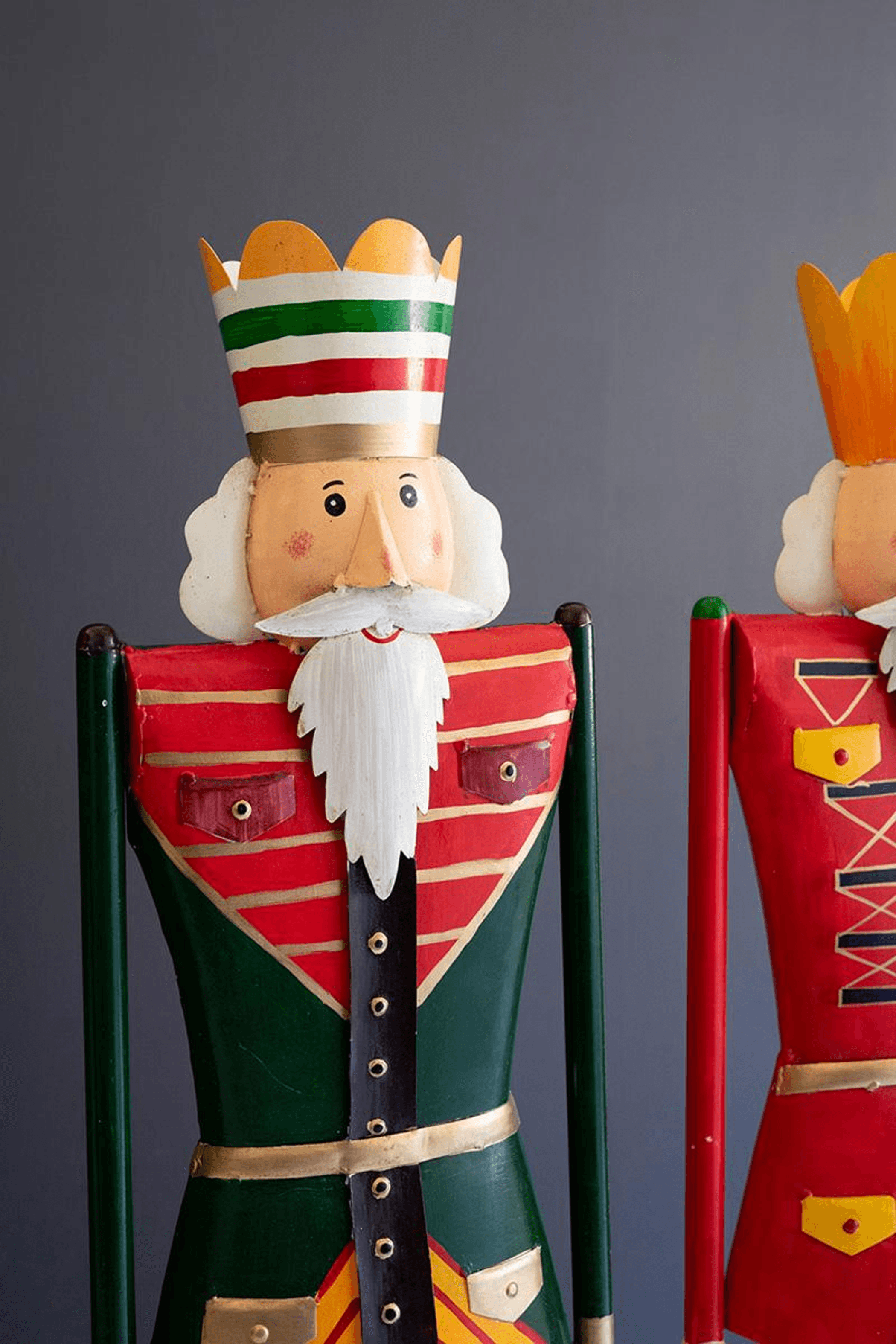 Painted nutcracker set: two wooden figures with tall hats, red-and-green striped coats