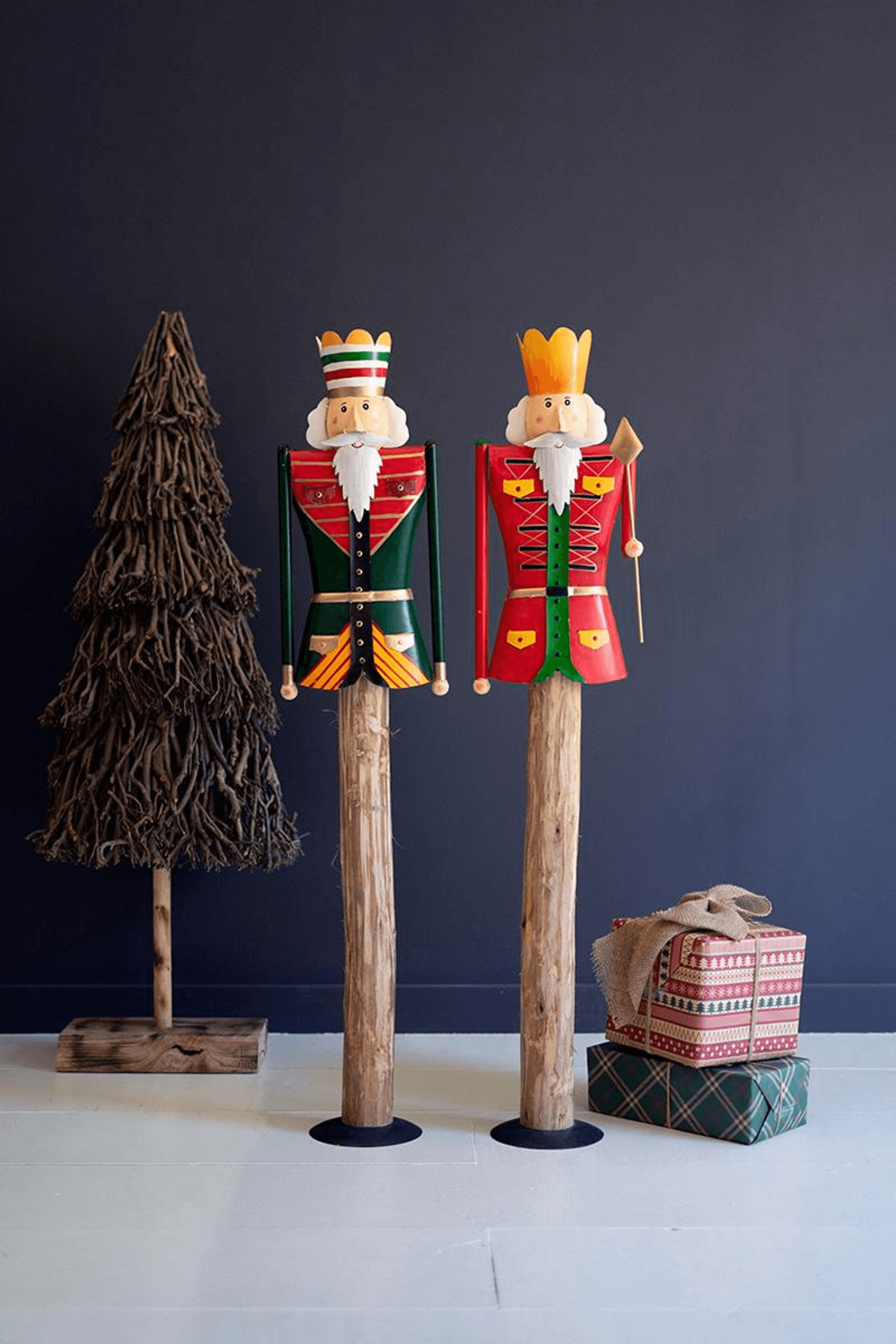 Painted nutcracker set on wooden stands with small tree and gift box decor