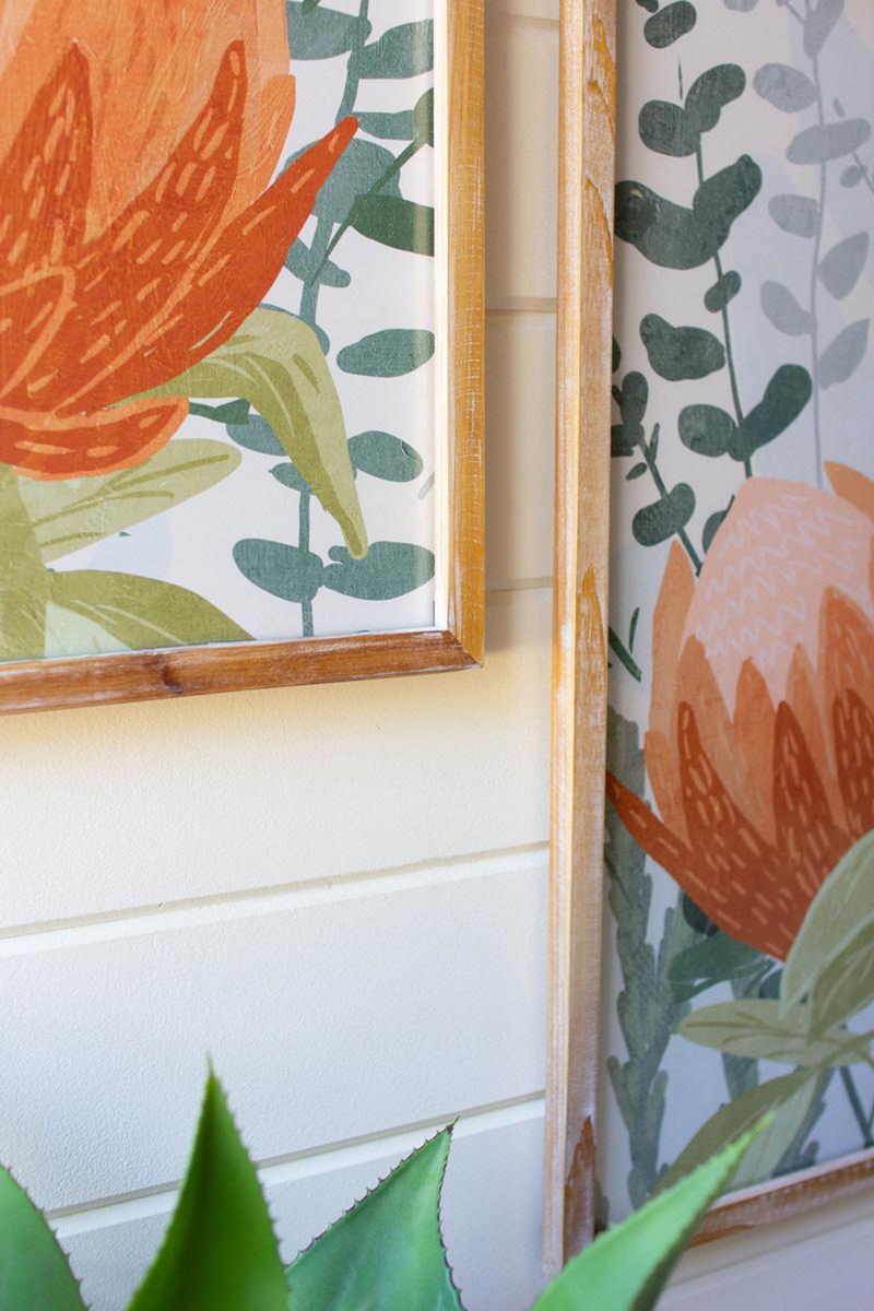 Under-glass framed botanical print close-up with orange protea petals and leafy green pattern