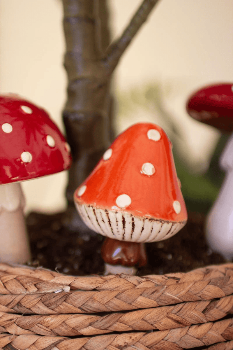 Close-up of ceramic mushroom plant stake with red cap and white spots
