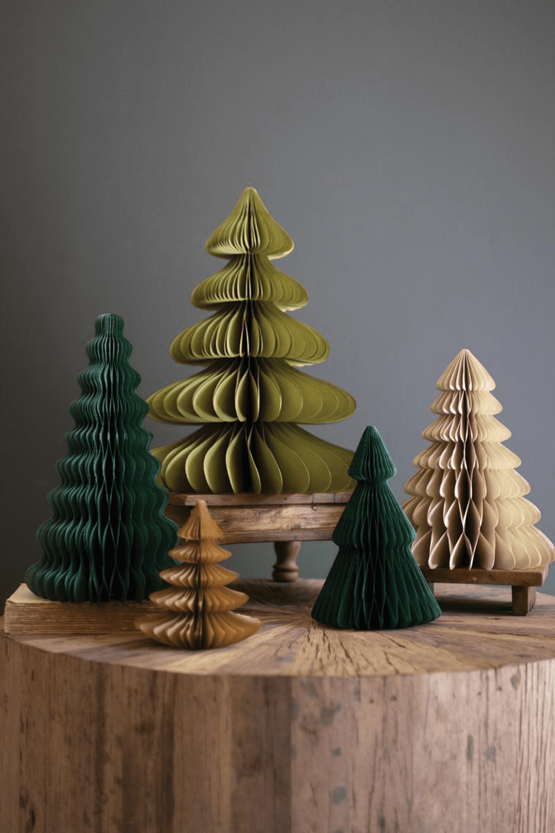 Paper accordion Christmas tree set with assorted green and tan sizes on wooden stand