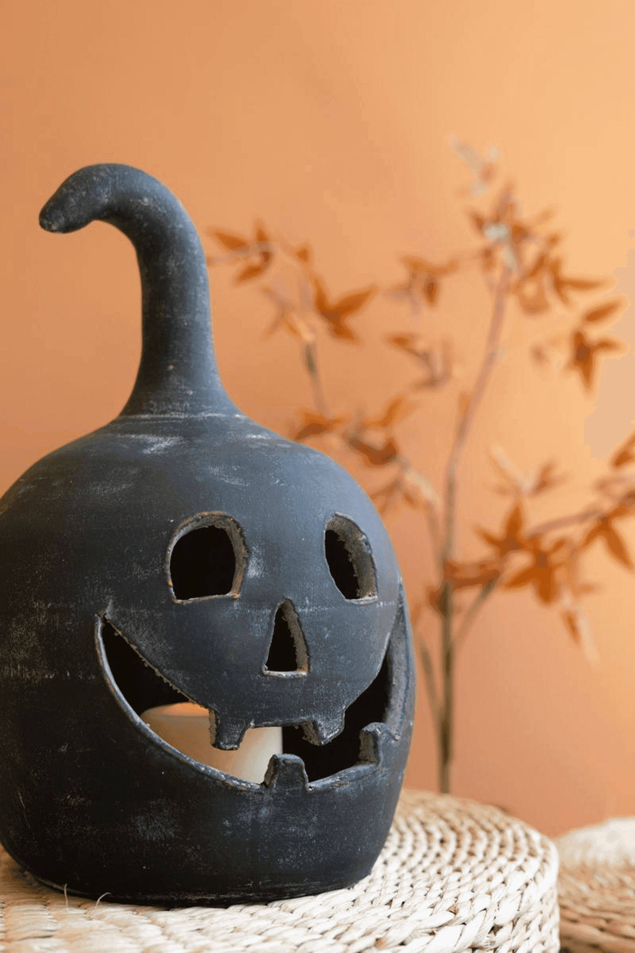 Black clay jack-o-lantern candle holder with carved face and top handle