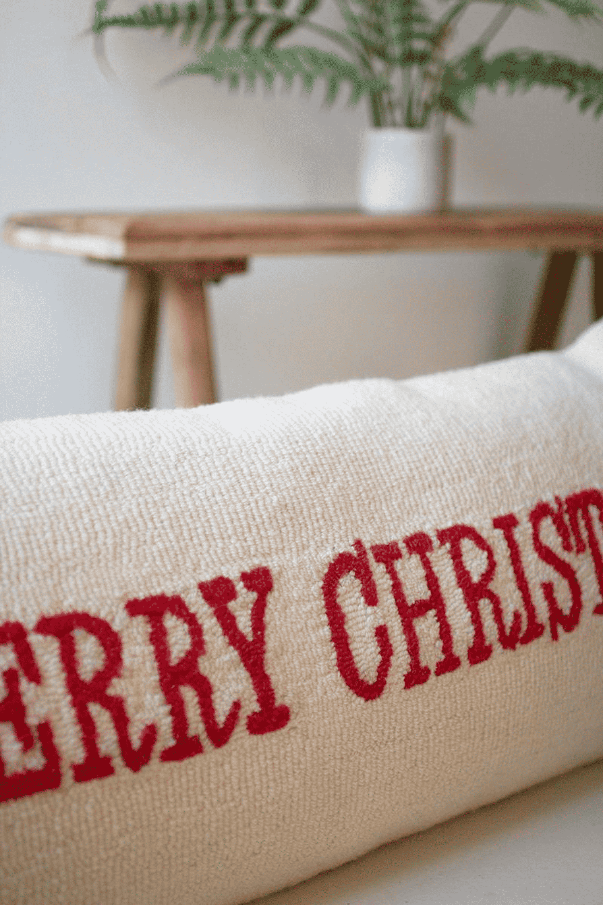 Cream hand-hooked throw pillow with red Merry Christmas embroidery