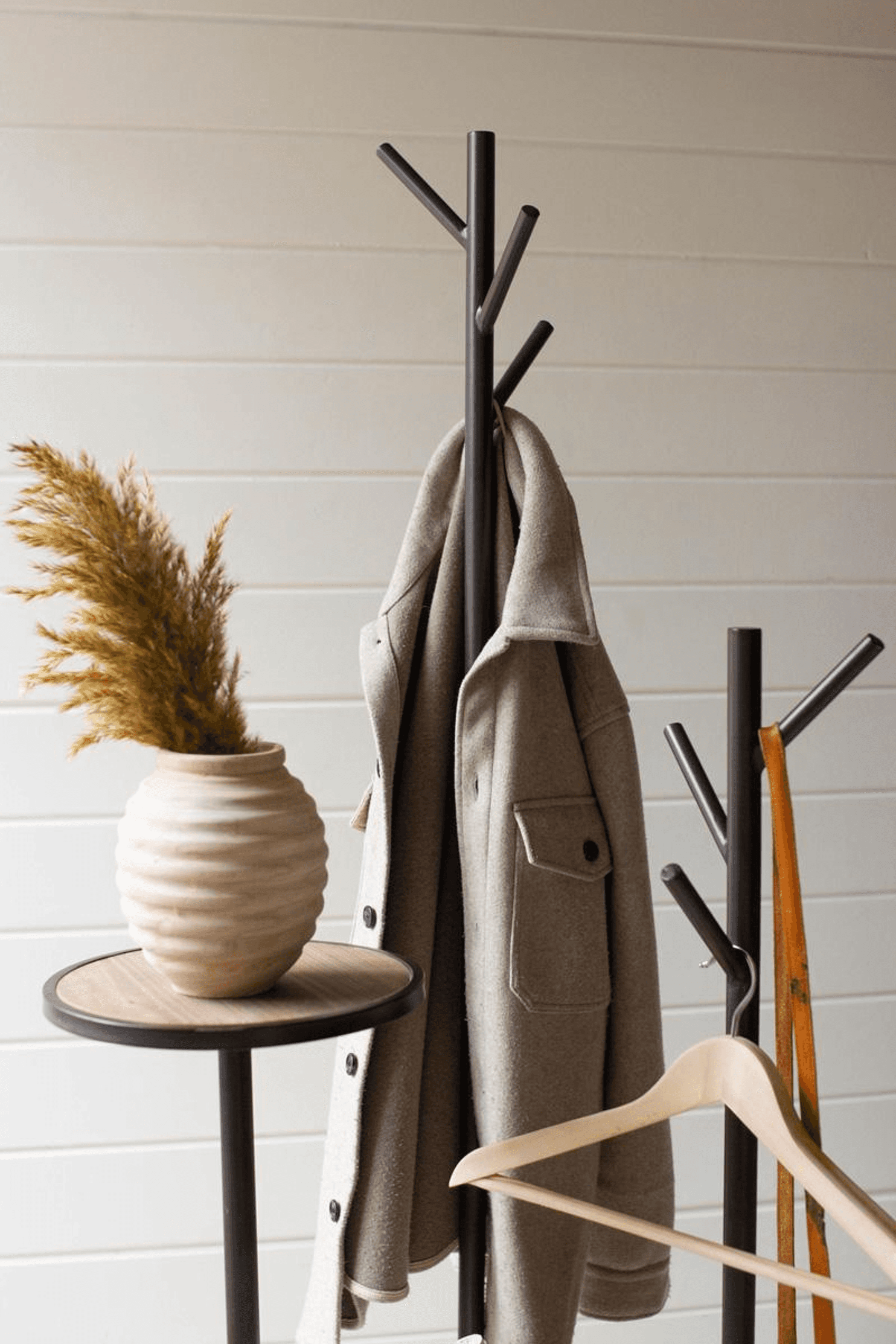Gray metal coat rack with round shelves, angled hooks, and wooden side posts.