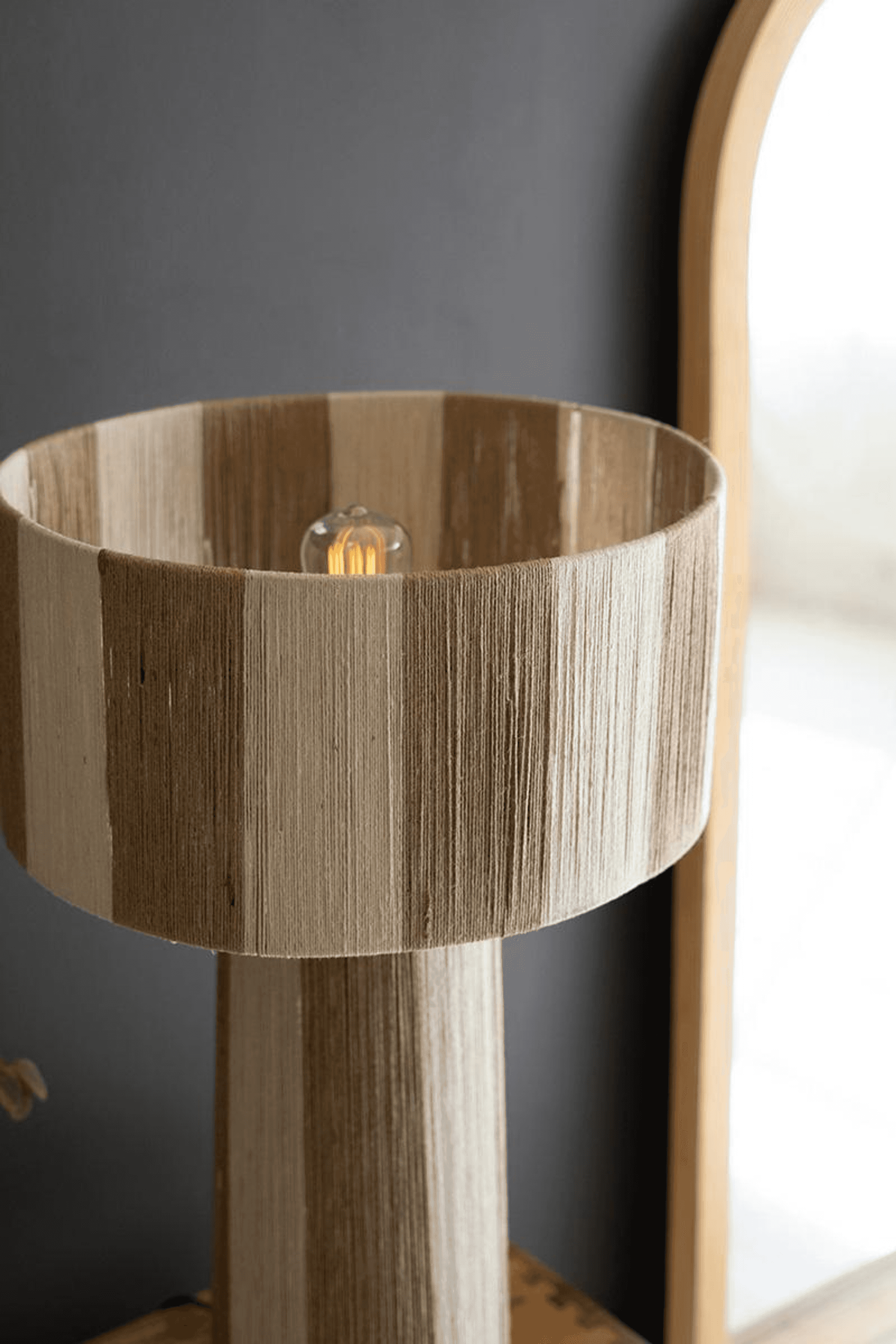 Natural jute table lamp with round beige shade and textured vertical body