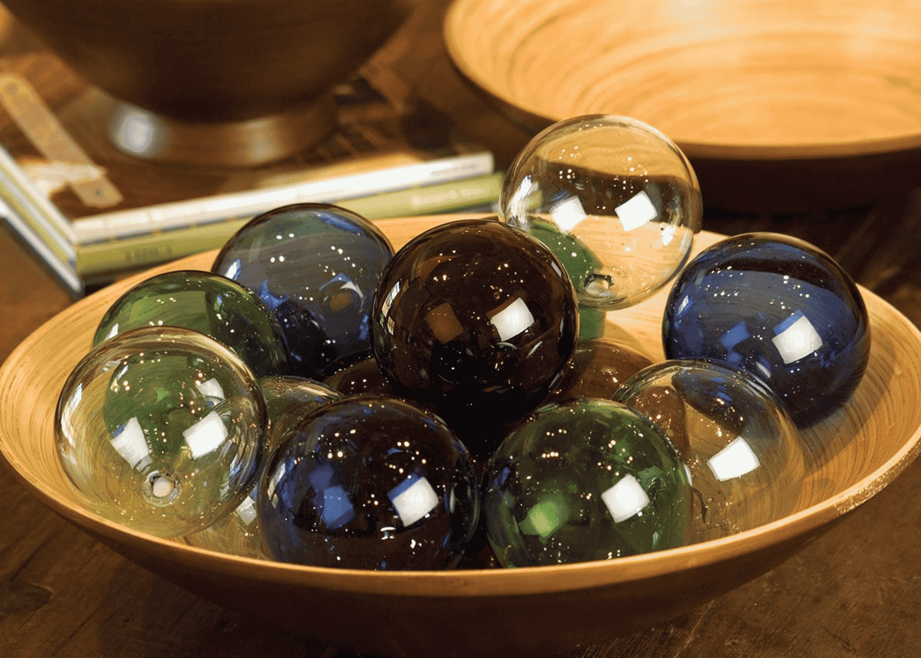 Green recycled glass balls with dark blue and amber, in a bowl