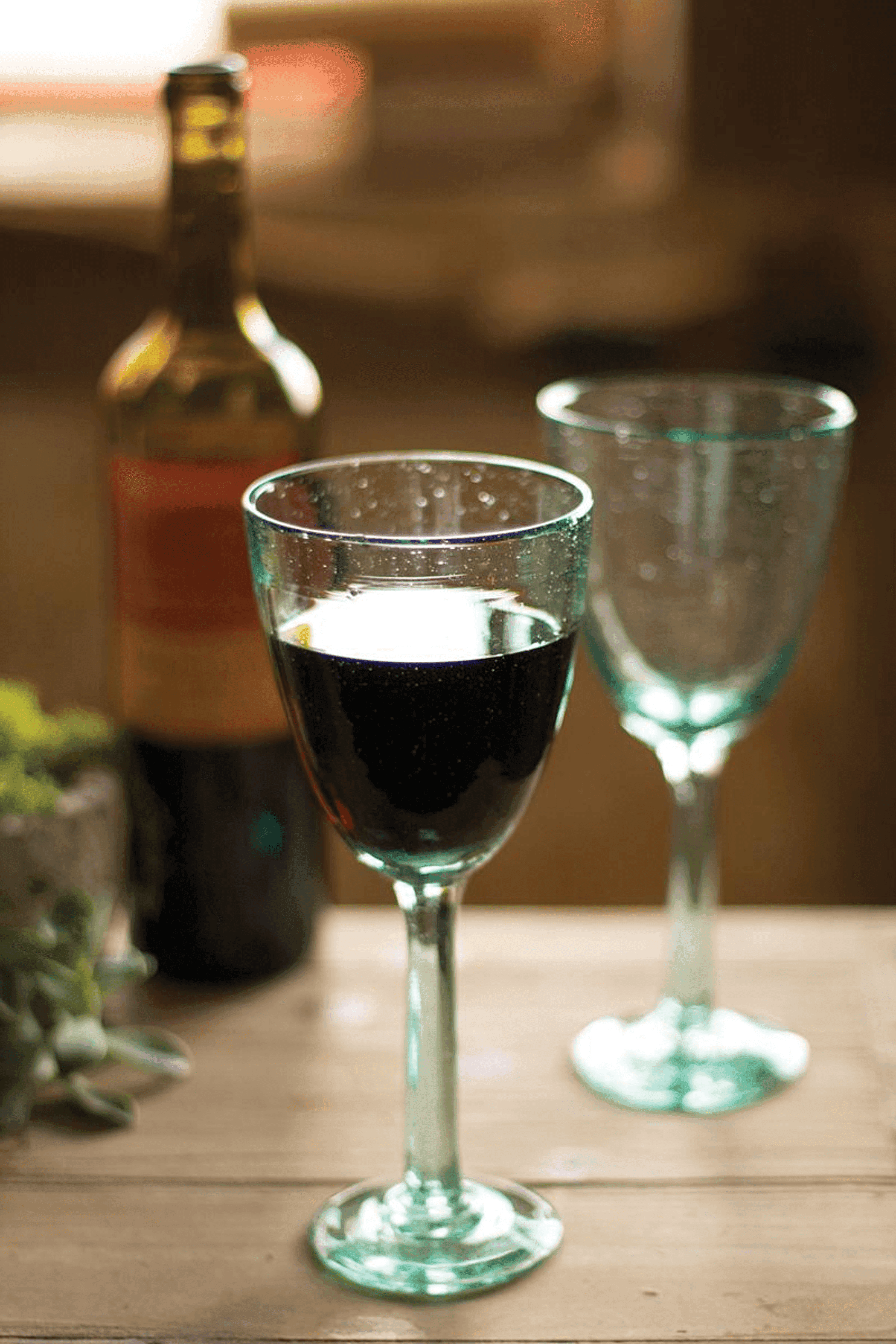 Recycled wine glass, clear stemware filled with dark red wine