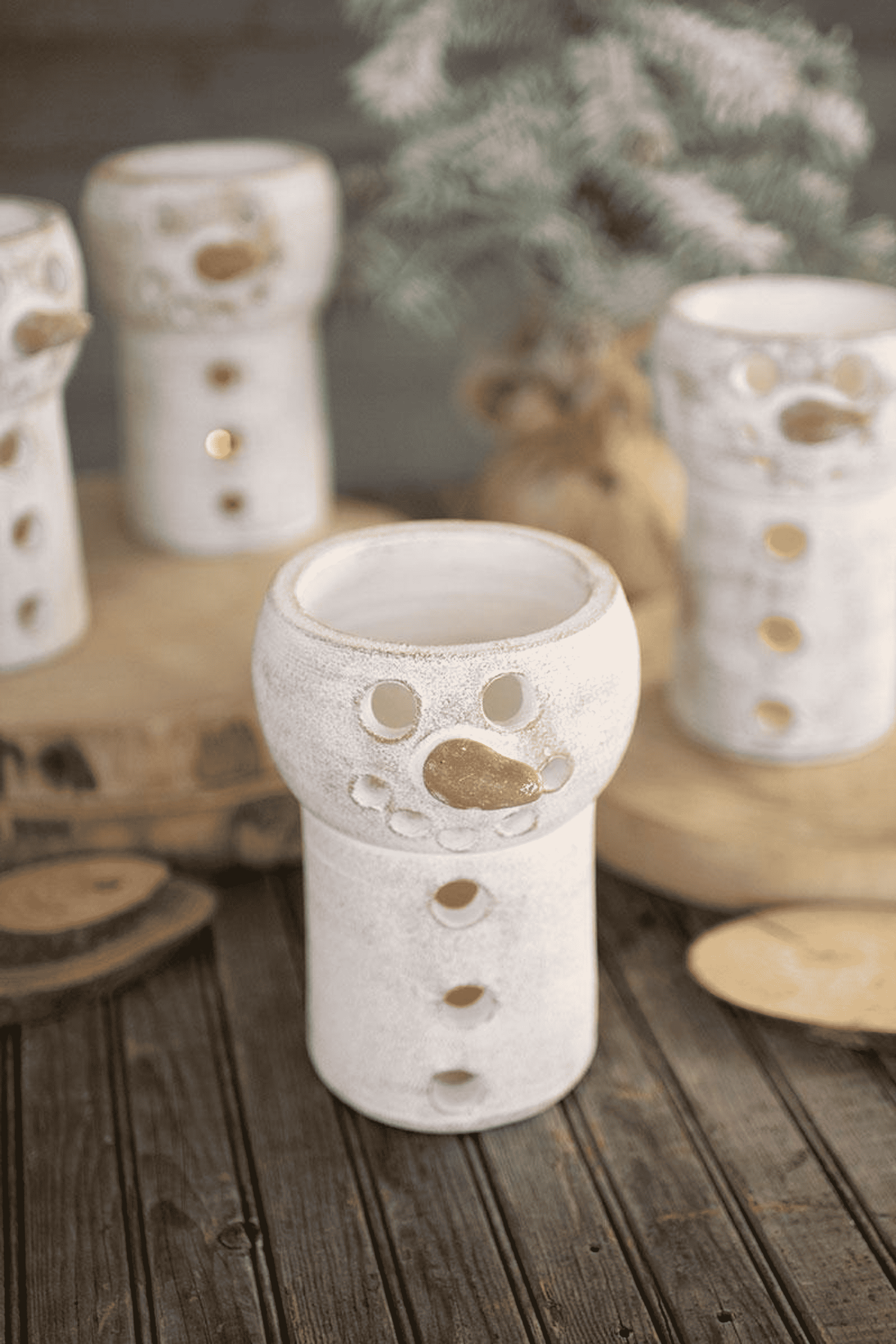 White ceramic snowman luminary cylinder with cutout eyes, nose, and flame opening