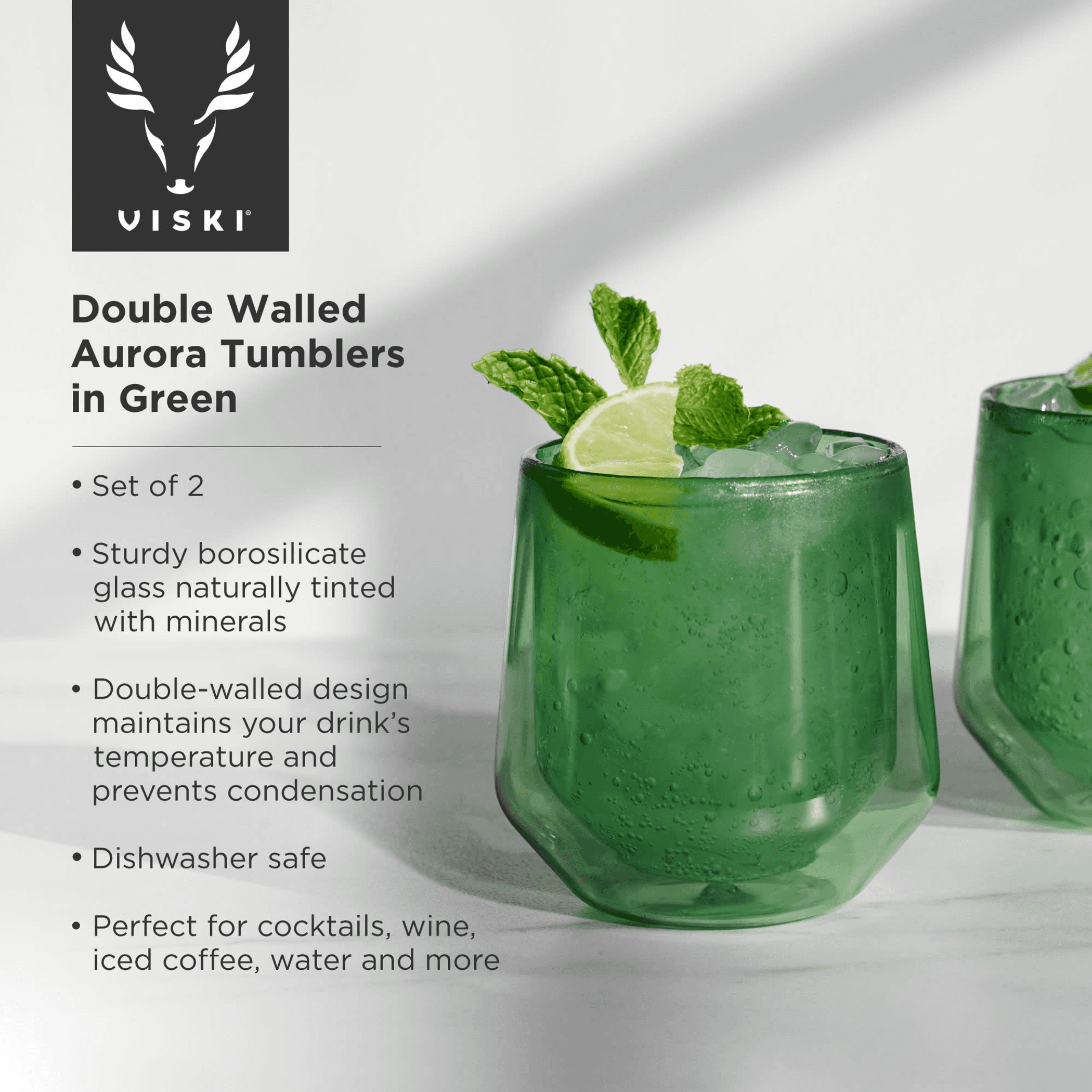 Green double-walled aurora tumbler glasses with mint leaves and condensation