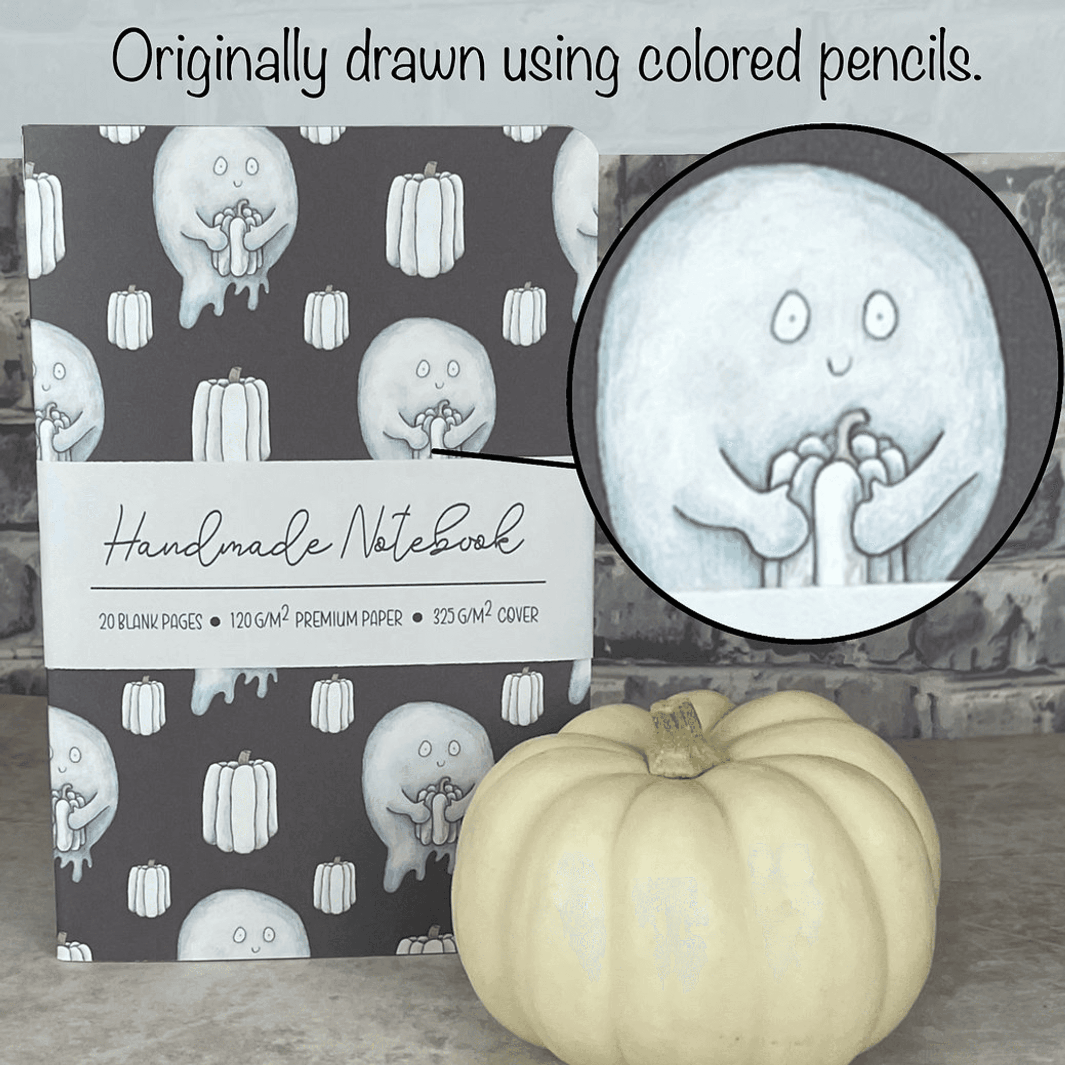 Notebook cover with hand-drawn light blue ghost and pumpkin illustration in colored pencil style