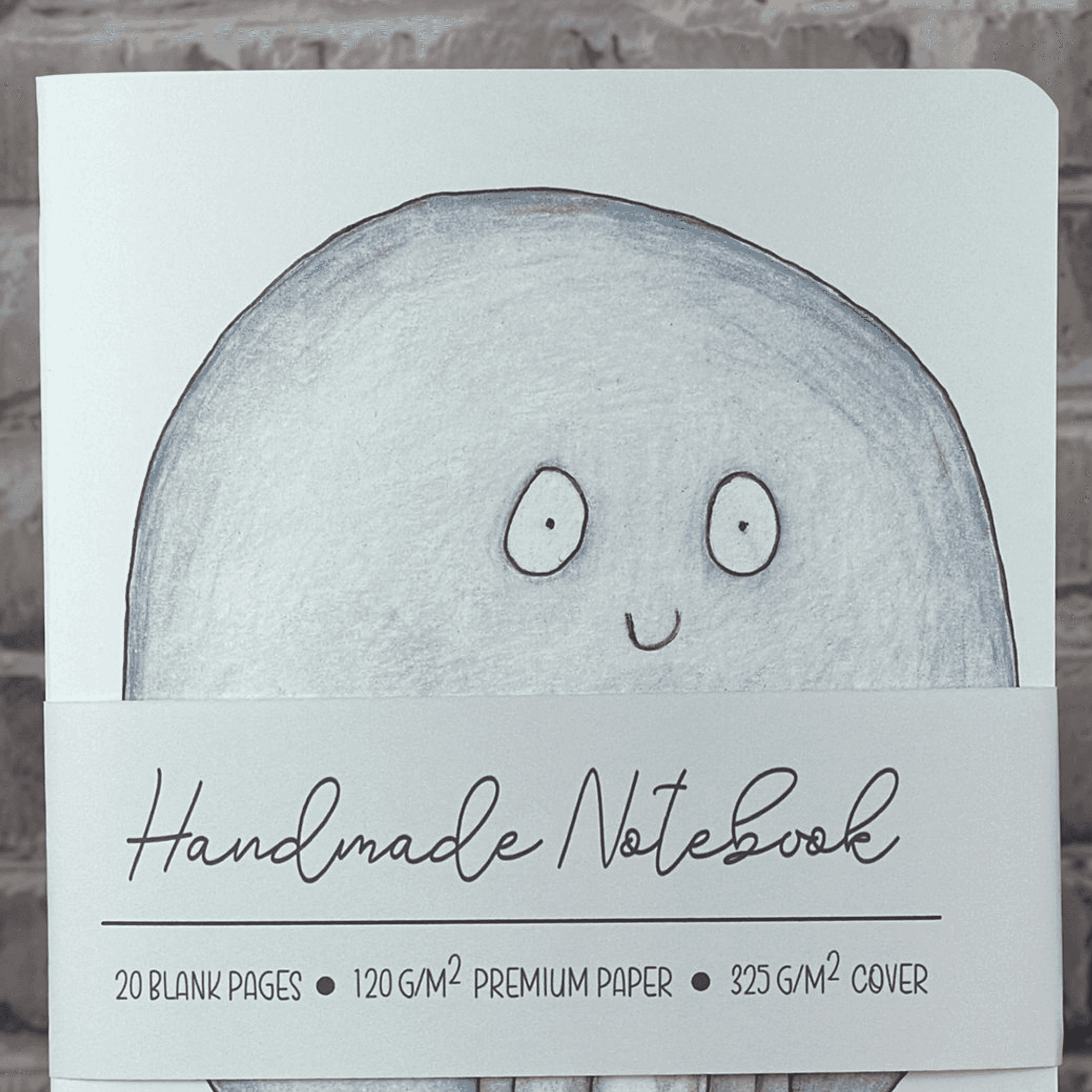 Handmade pumpkin ghost notebook close-up showing light blue ghost face and stitched cover label