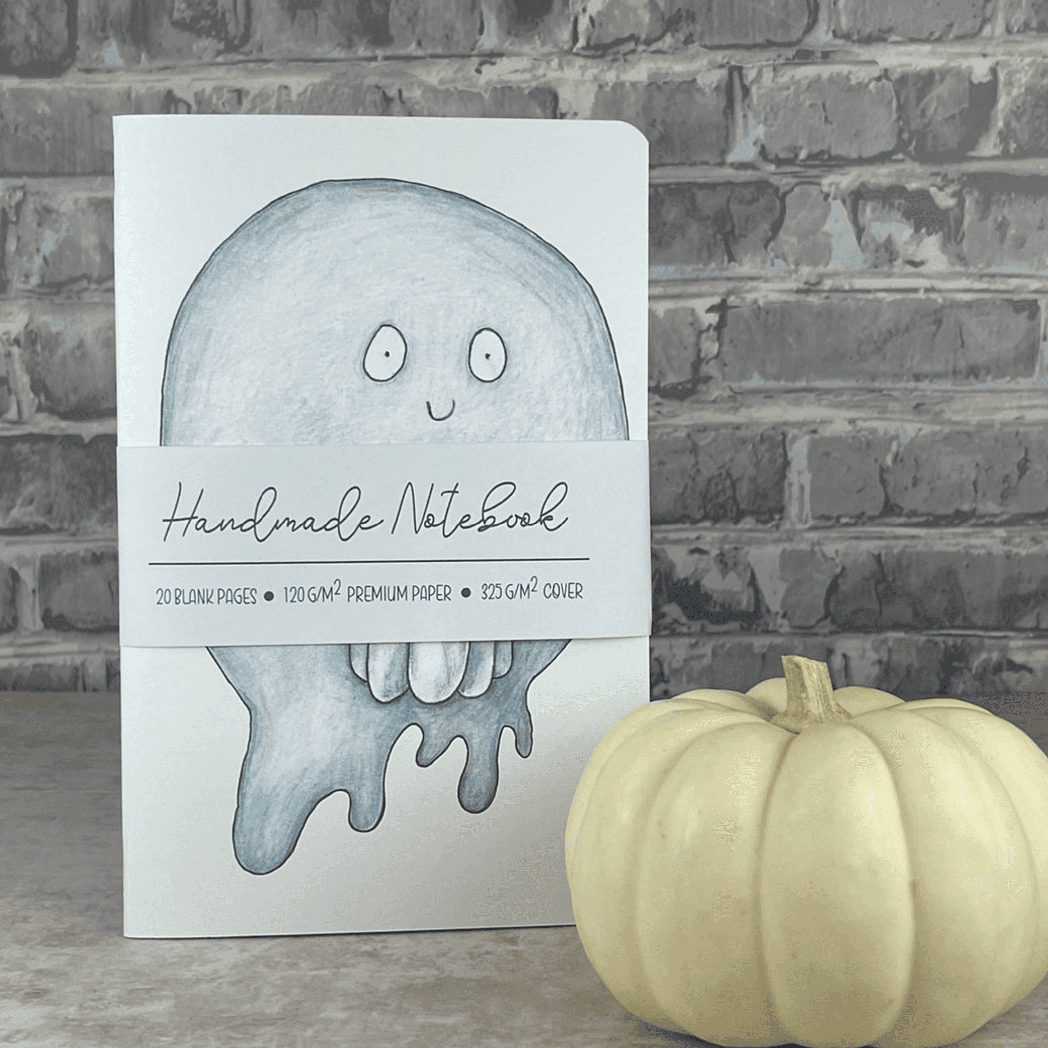 Handmade pumpkin ghost notebook with light blue cover art featuring drippy ghost character
