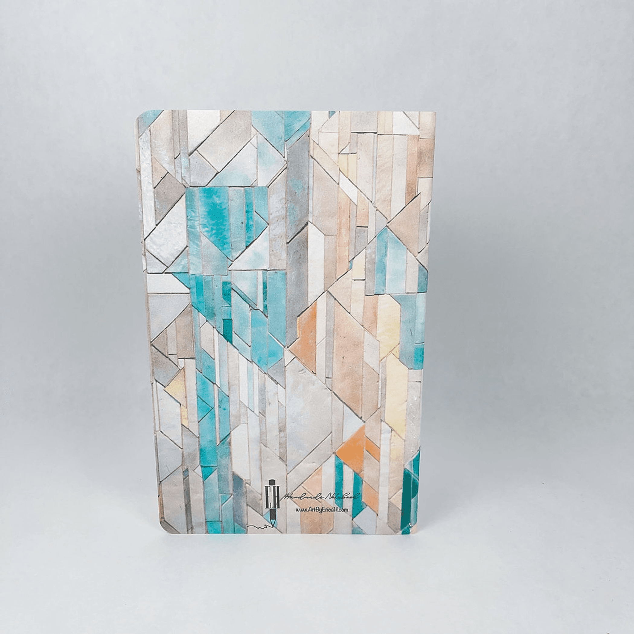 Handmade notebook side view showing geometric tile cover and stacked pages.