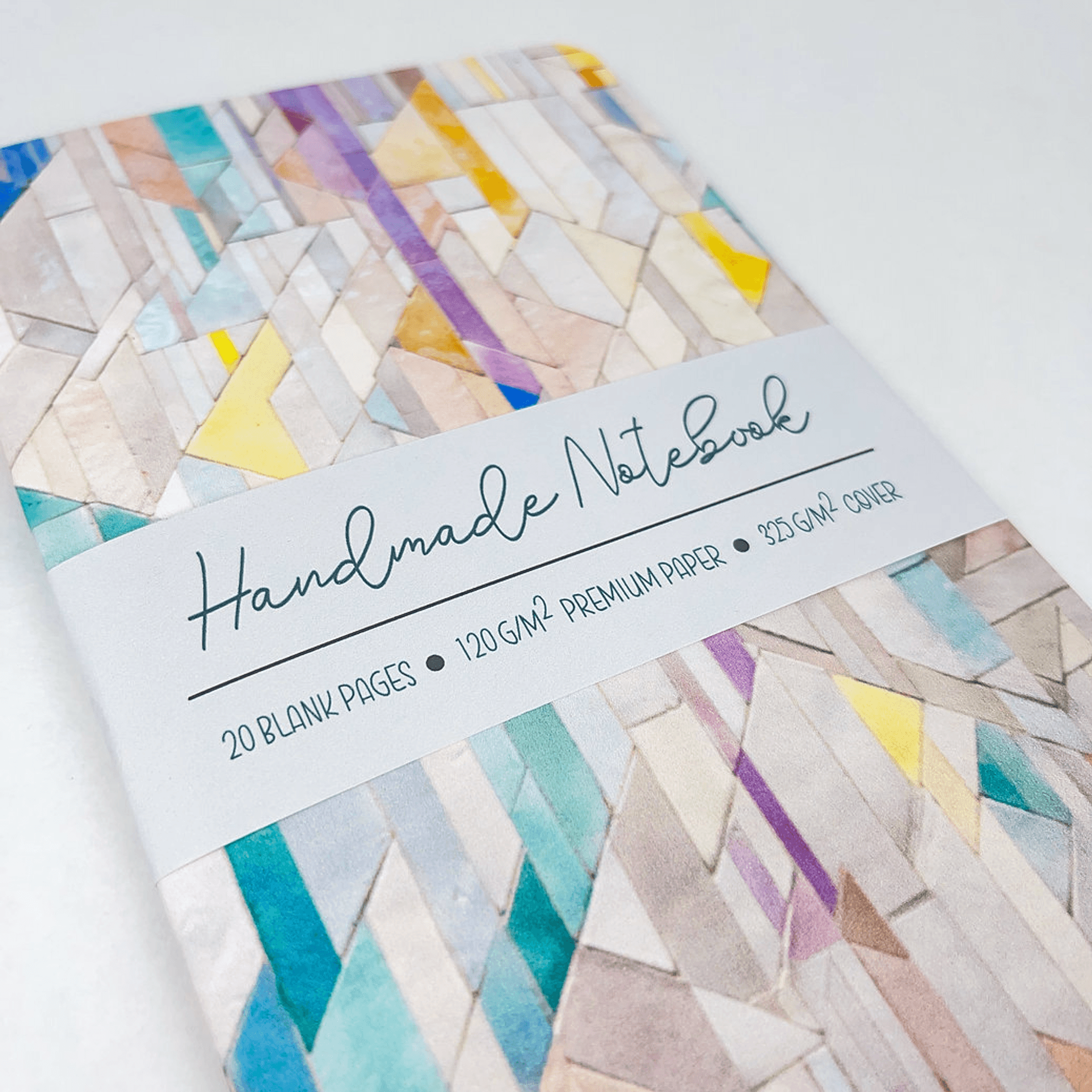 Handmade notebook with geometric tile cover and cursive label across the front.
