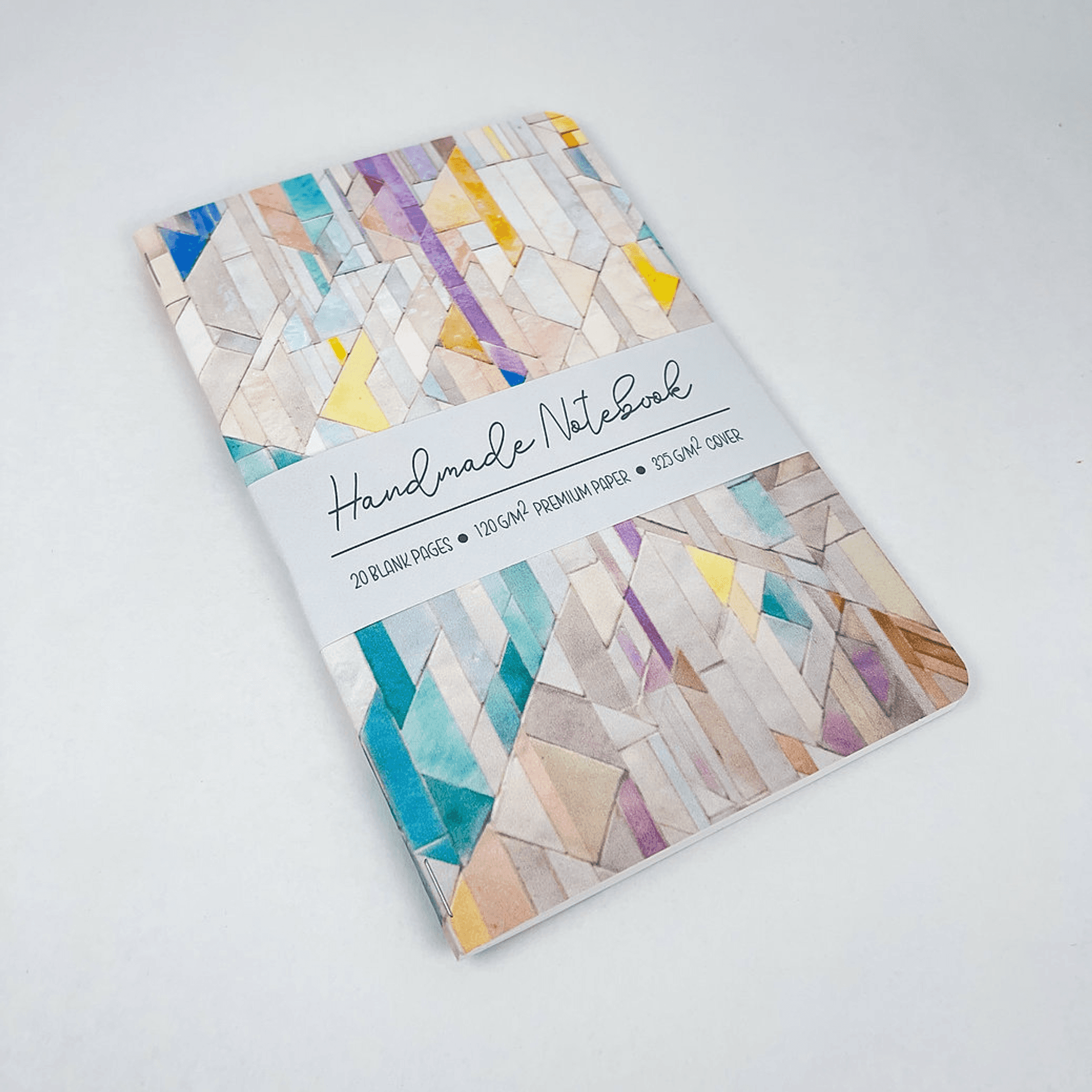 Handmade notebook closed, geometric tile cover with label strip on the front.