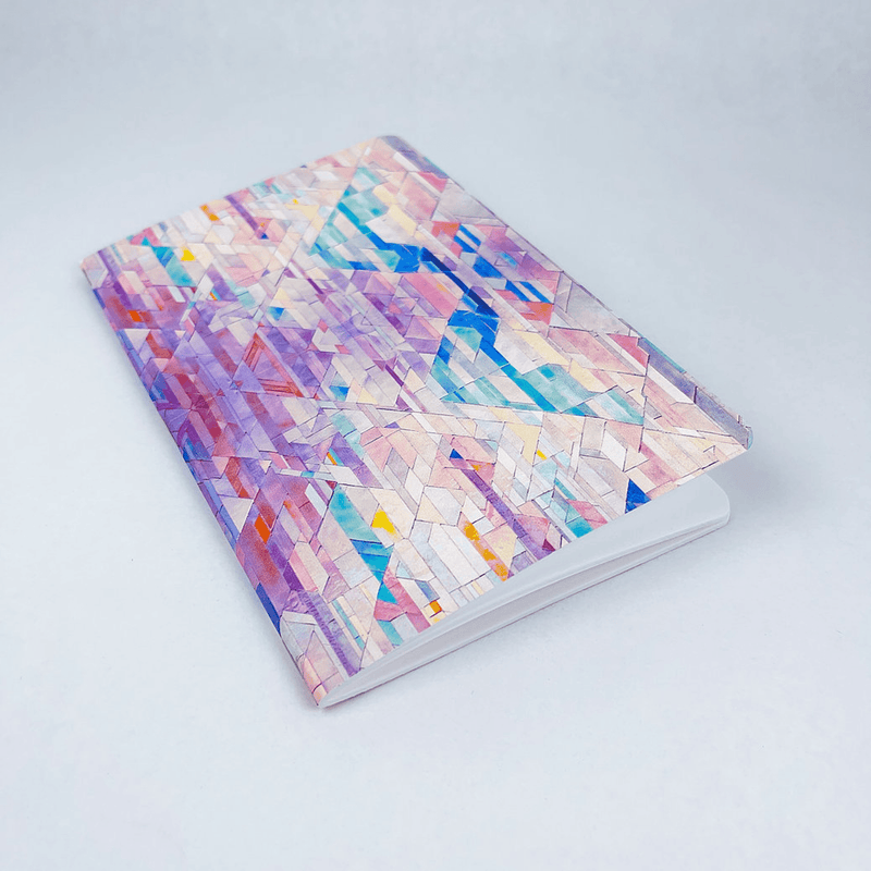Handmade notebook with colorful geometric tile cover, shown at an angled side view