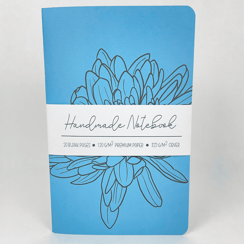 Blue handmade notebook with hand-drawn teal flower and title label