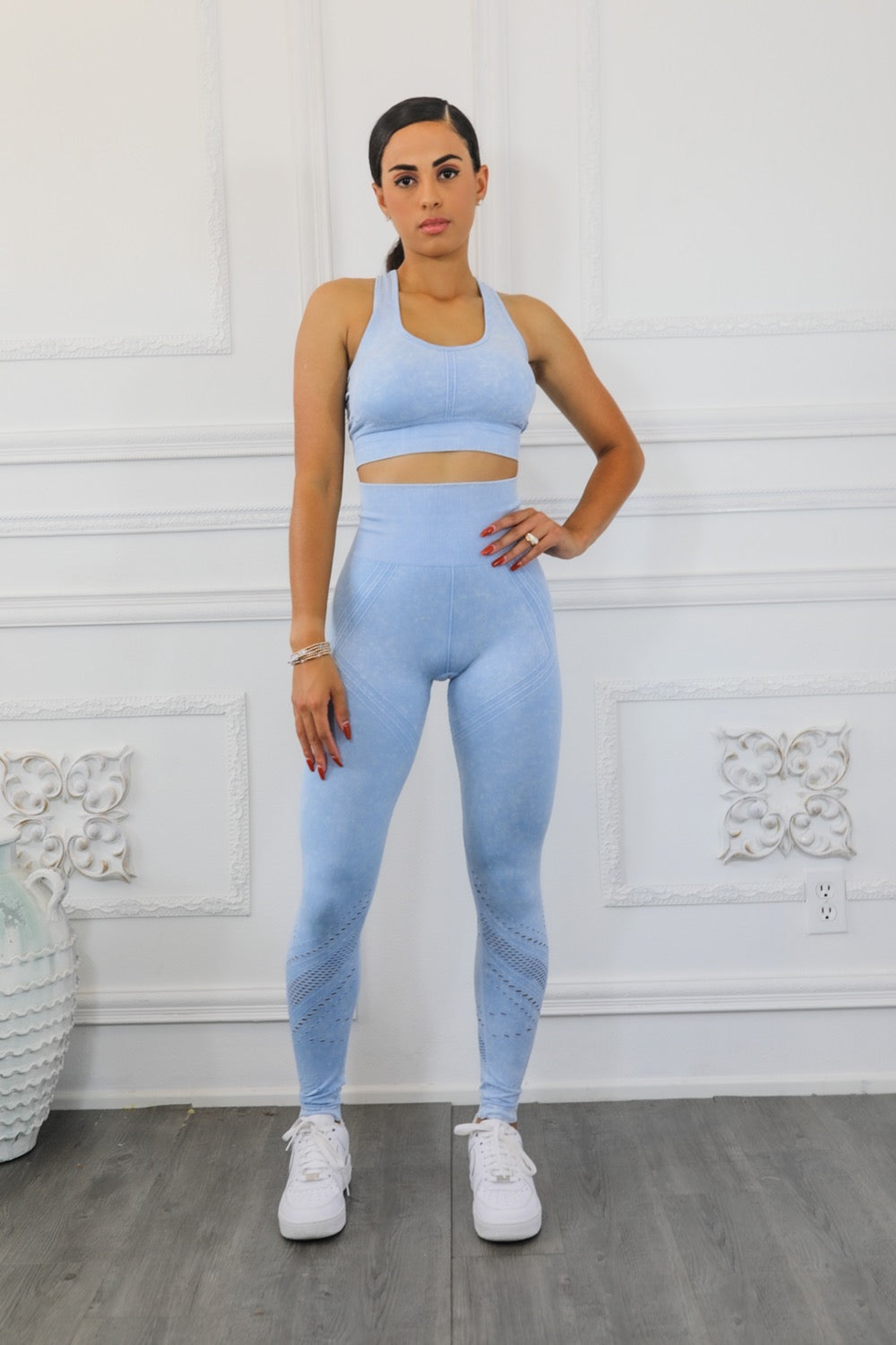 Blue sports bra and leggings set with perforated side seam pattern