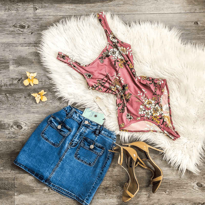 Pink floral sleeveless bodysuit laid flat, scoop neck, fitted high-cut legs