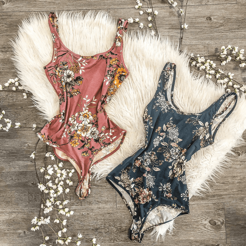 Pink floral sleeveless bodysuit with scoop neck and fitted high-cut leg openings
