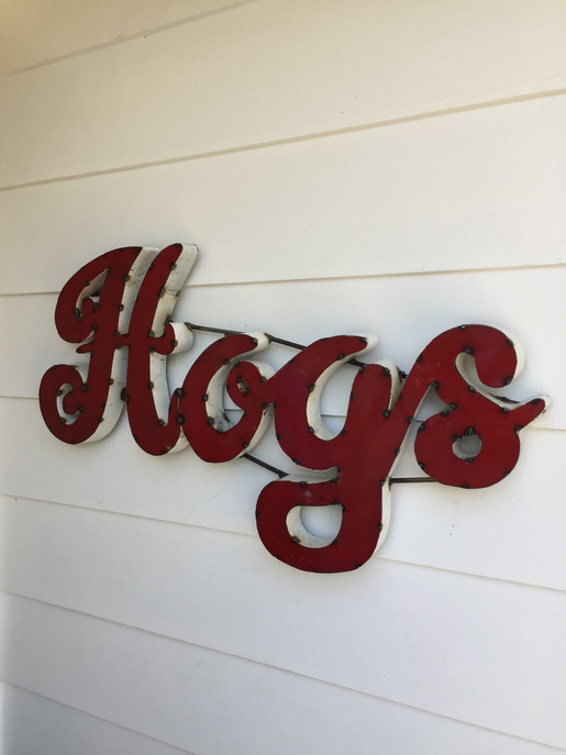 Recycled metal wall decor spelling “Hogs” in red and silver on wall