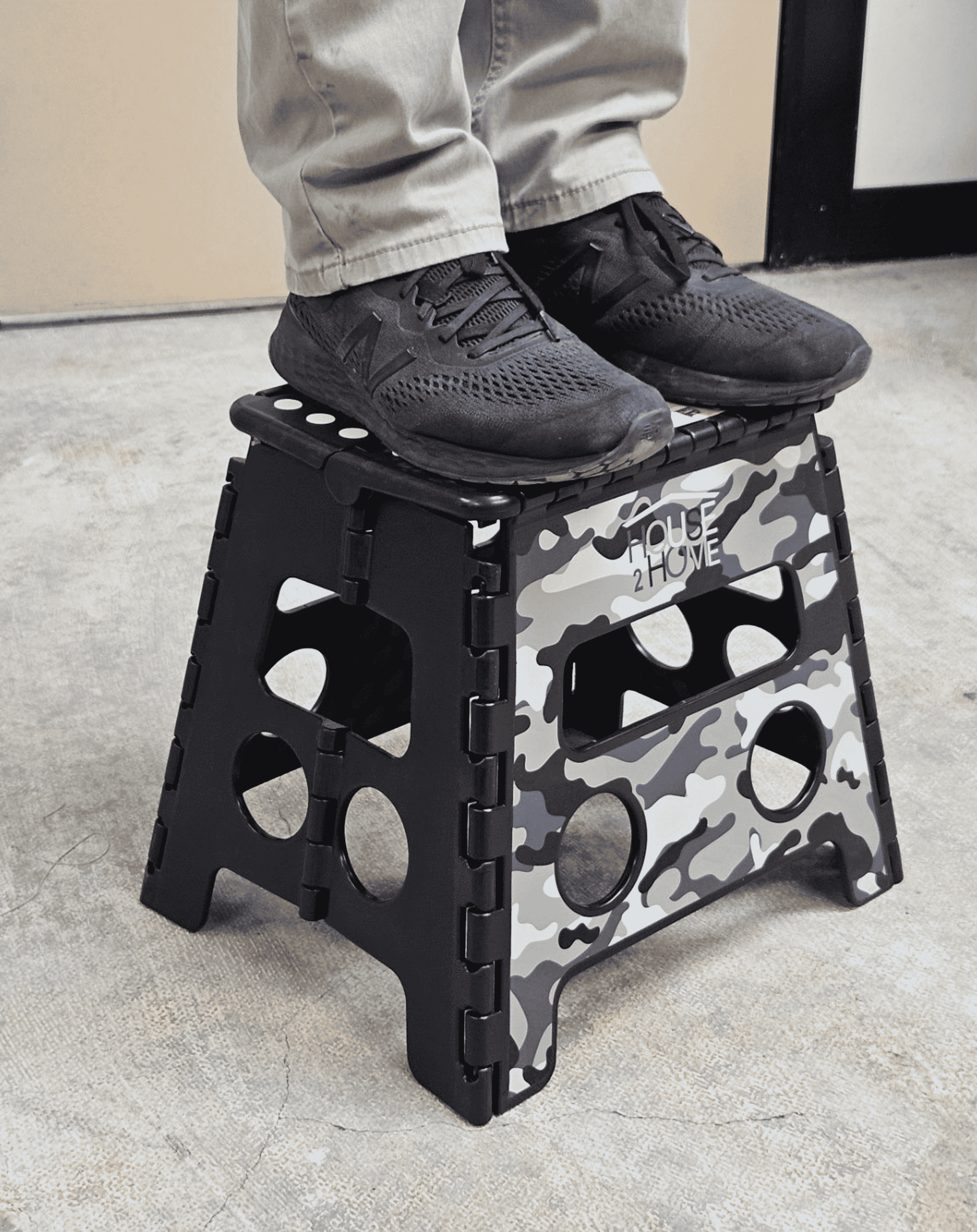 Black camouflage step stool with dot grip top, shown in use with shoes