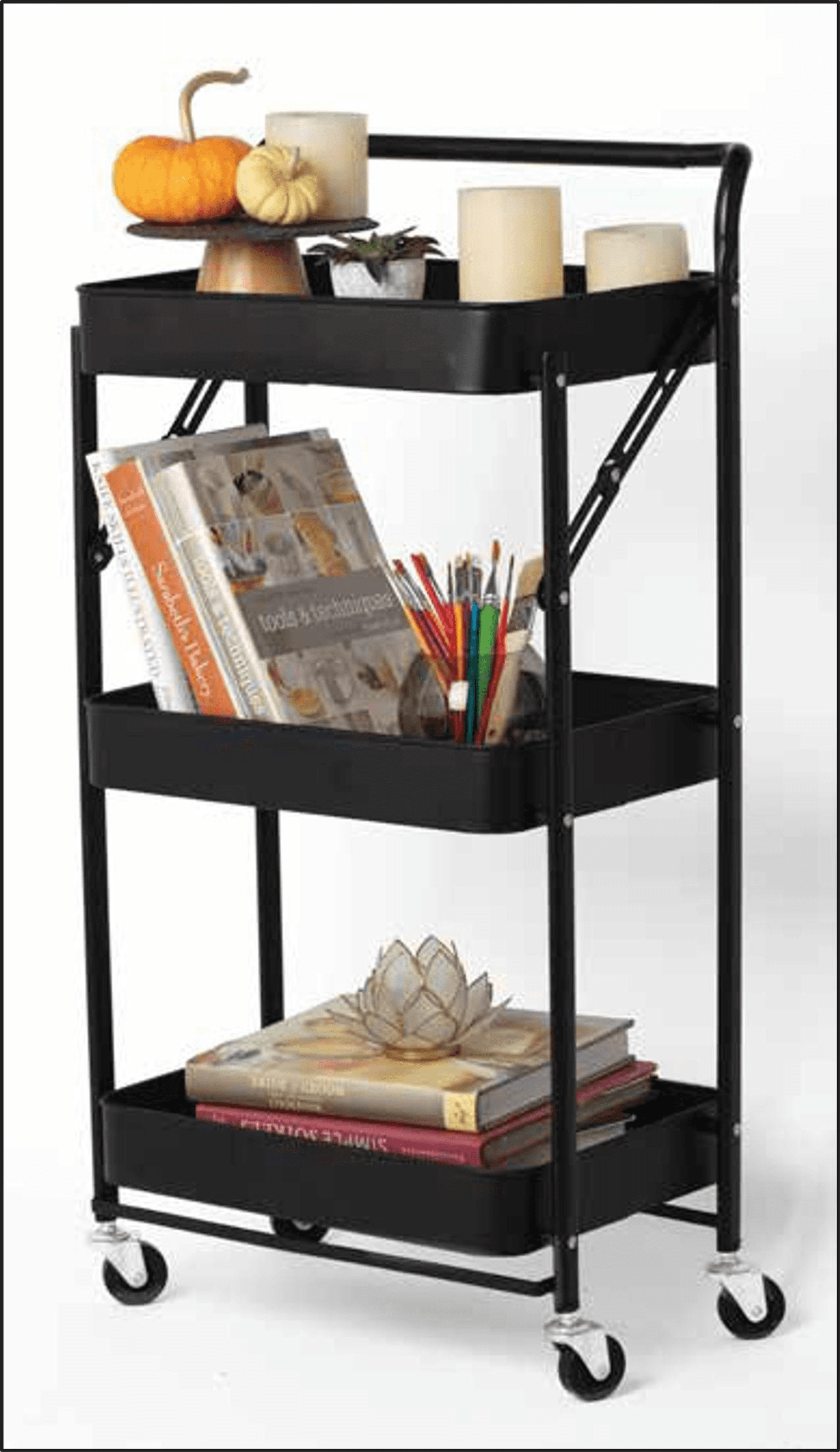 Black 3-tier foldable rolling trolley holding books, art supplies, and candles