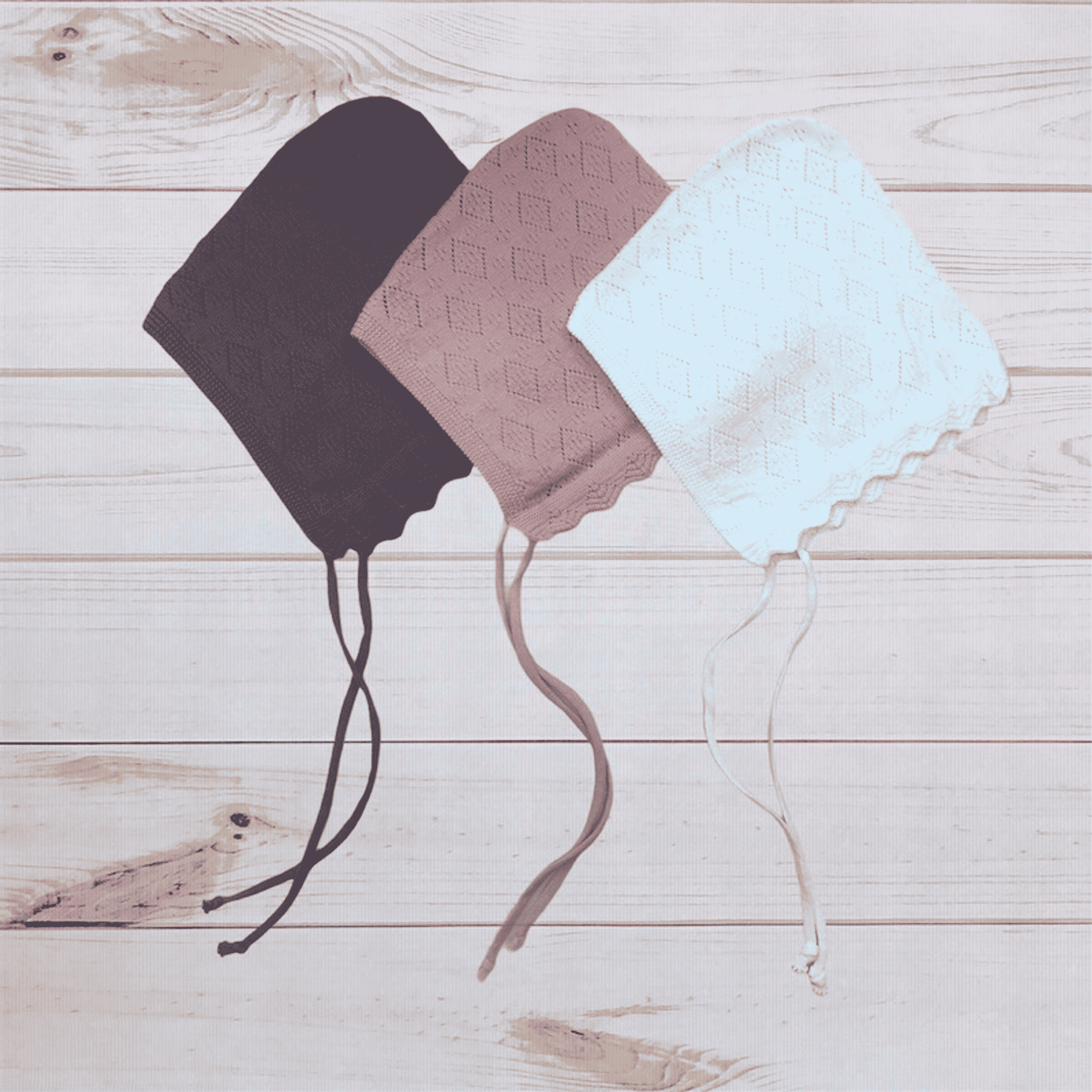 Knit bonnets in dark plum, mauve, and light blue with dangling tie strings