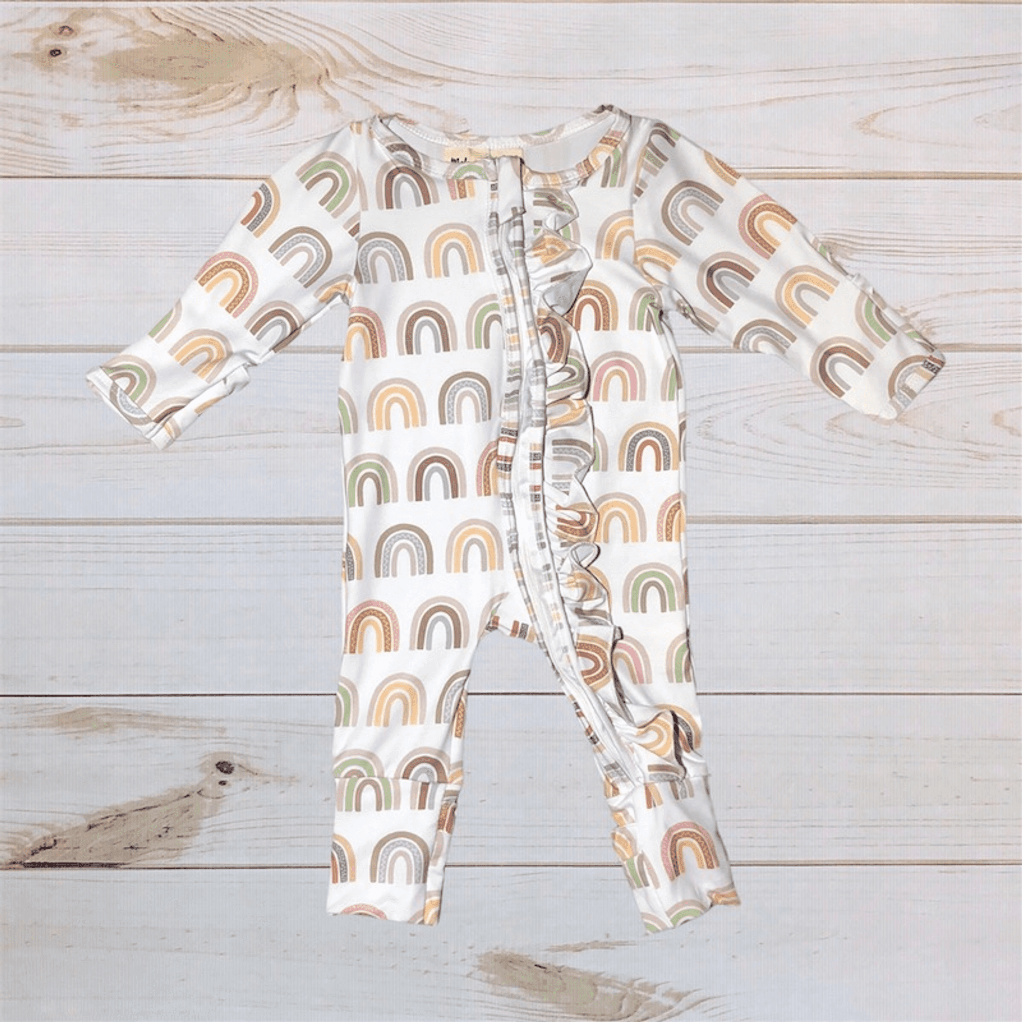Rainbow print zip-front romper with long sleeves, off-white base and footed legs