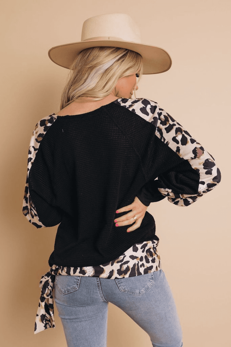 Black long-sleeve top with leopard print sleeves and tied waist at back