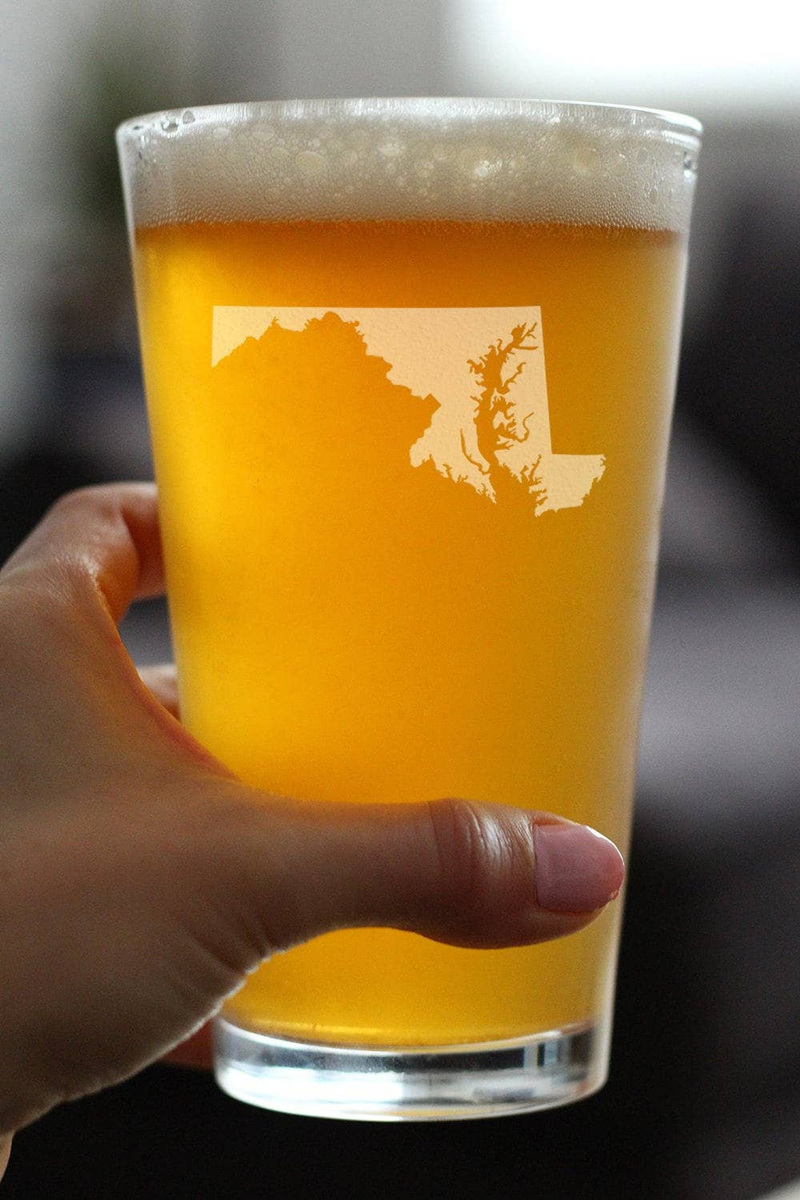 Pint beer glass held in hand, amber beer with etched Maryland outline on side
