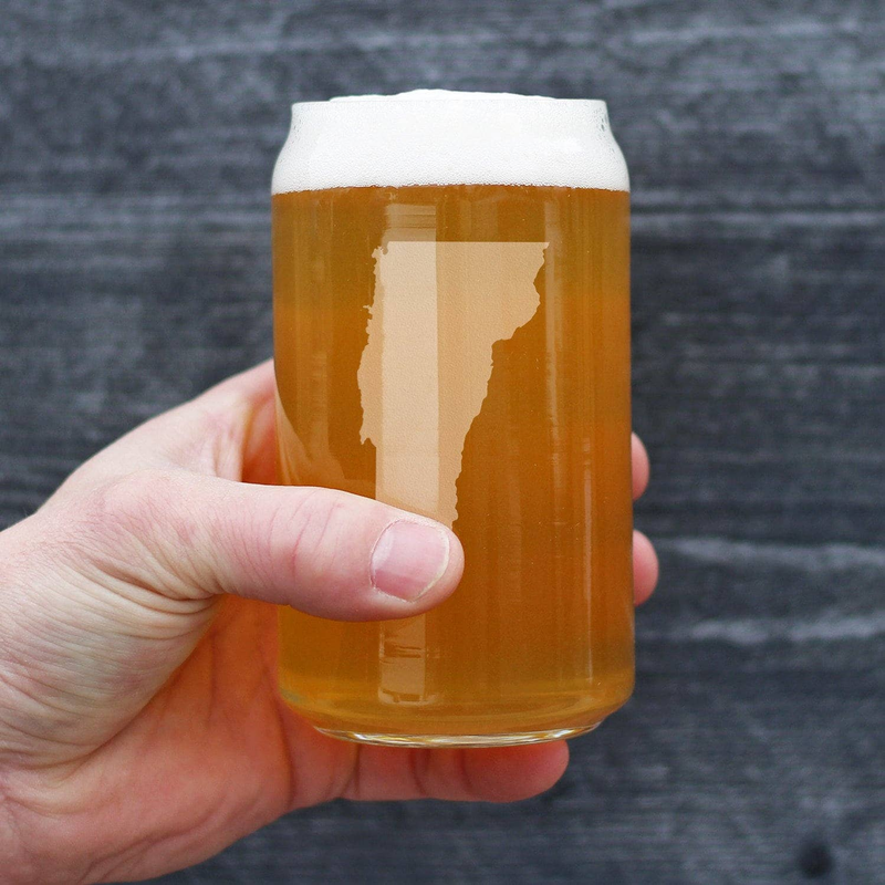 Handheld Vermont outline beer-can pint glass filled with amber beer and etched state