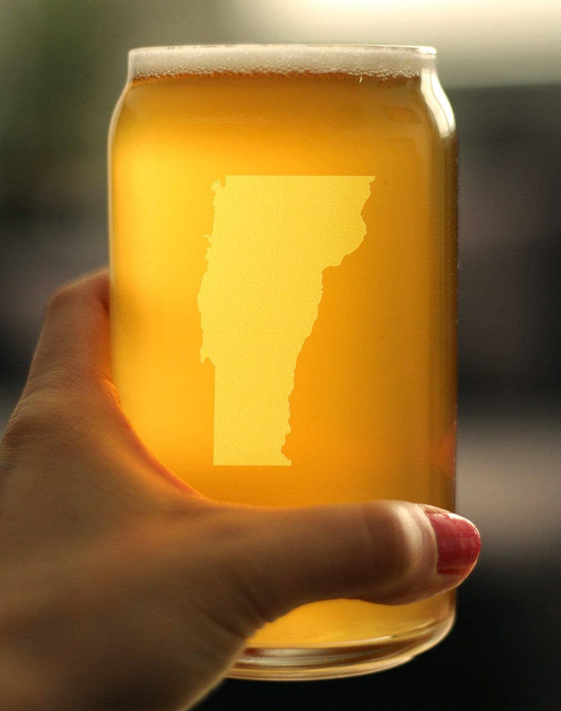 Hand holding Vermont outline beer-can pint glass with amber beer and etched state