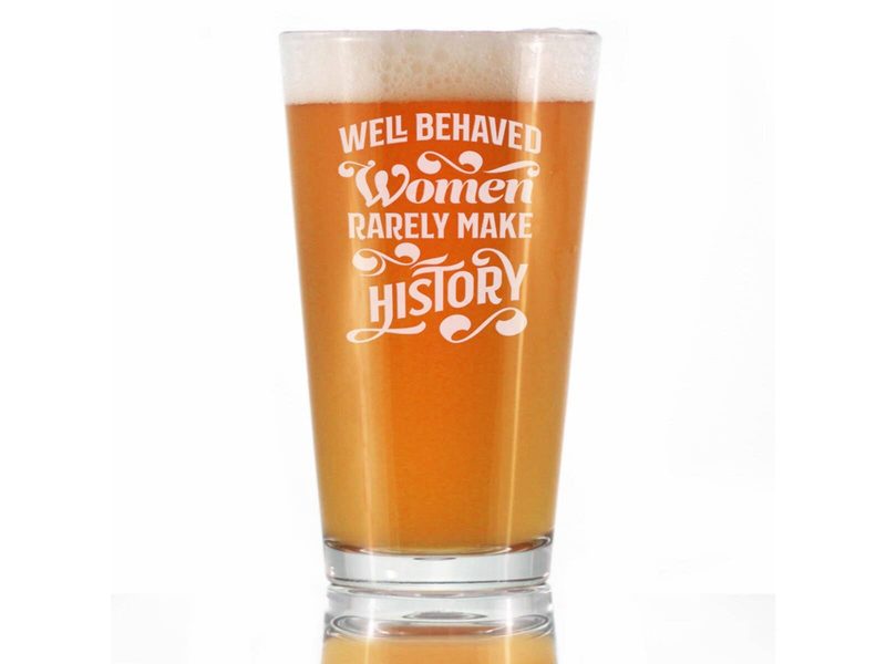 Beer pint glass with etched feminist slogan, amber beer fill with foam top
