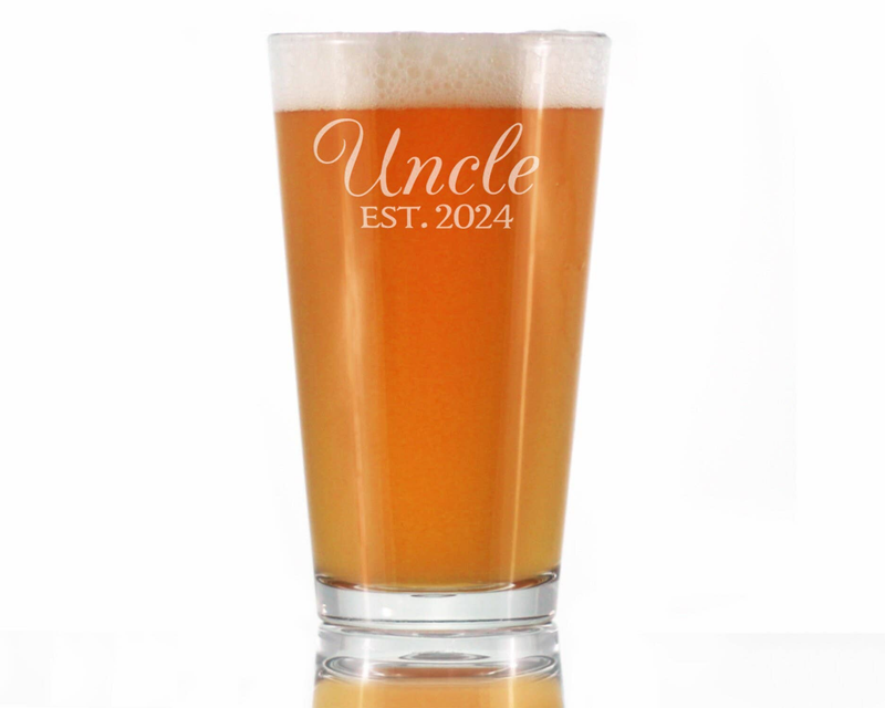 Uncle EST. 2024 etched pint glass filled with amber beer and foam head