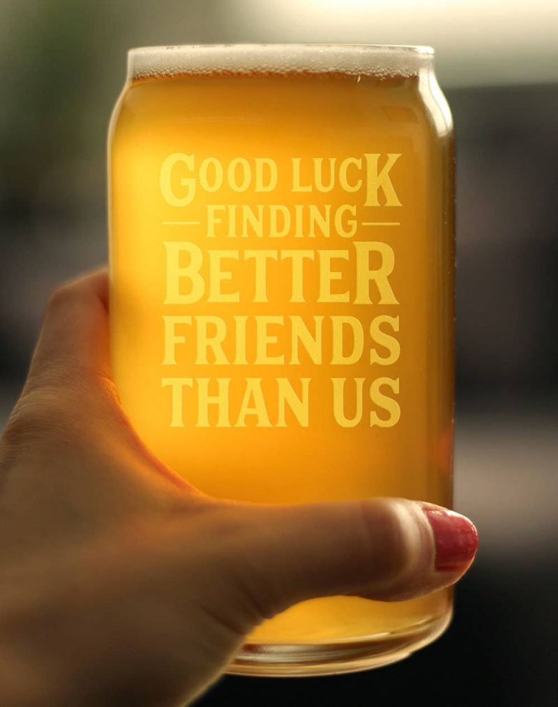 Hand holding beer can pint glass with amber beer and etched 'Good luck finding better friends'
