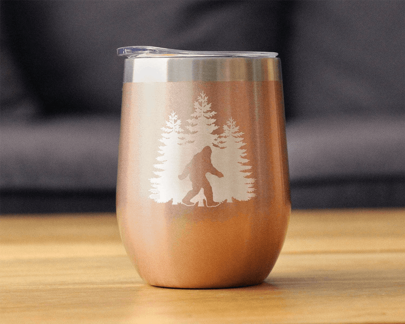 Beige insulated wine tumbler with laser-etched Bigfoot and pine trees design