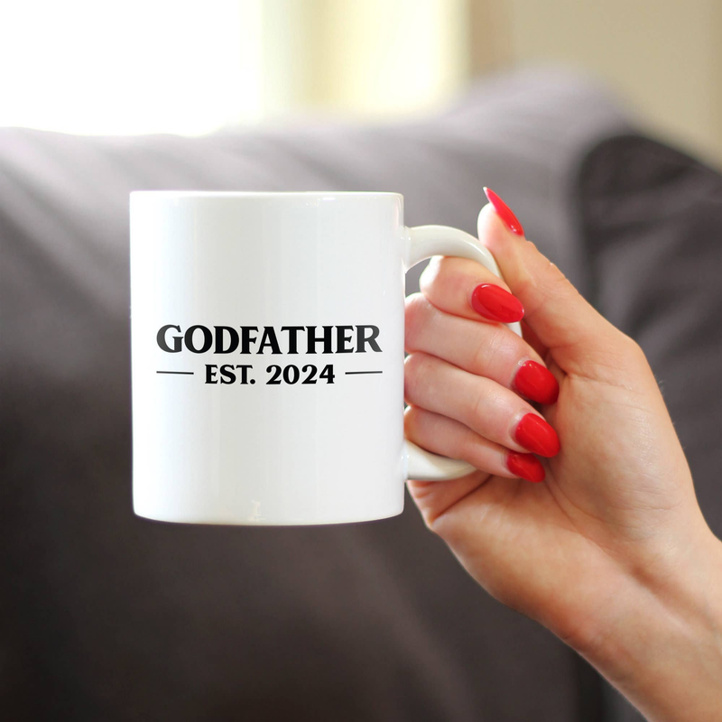 White ceramic coffee mug with handle, “GODFATHER” and “EST. 2024” printed on front.