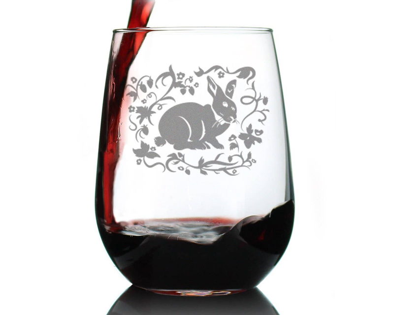 Stemless glass with etched rabbit and floral vines, filled with dark red wine