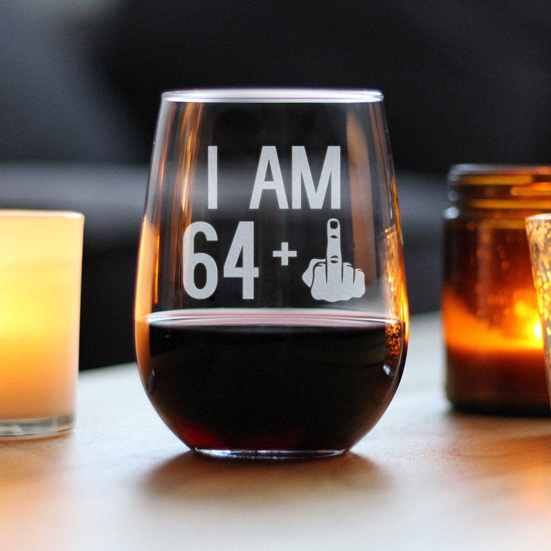 Stemless wine glass with etched "I AM 64" and middle finger graphic, dark wine