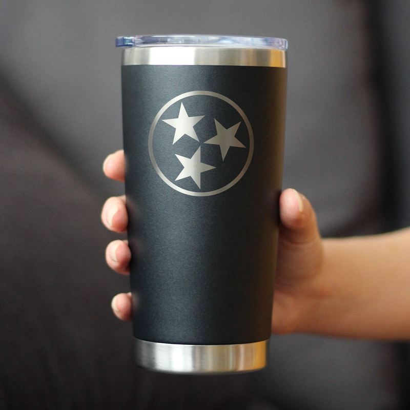 Black insulated travel tumbler with circular star logo, held in a hand