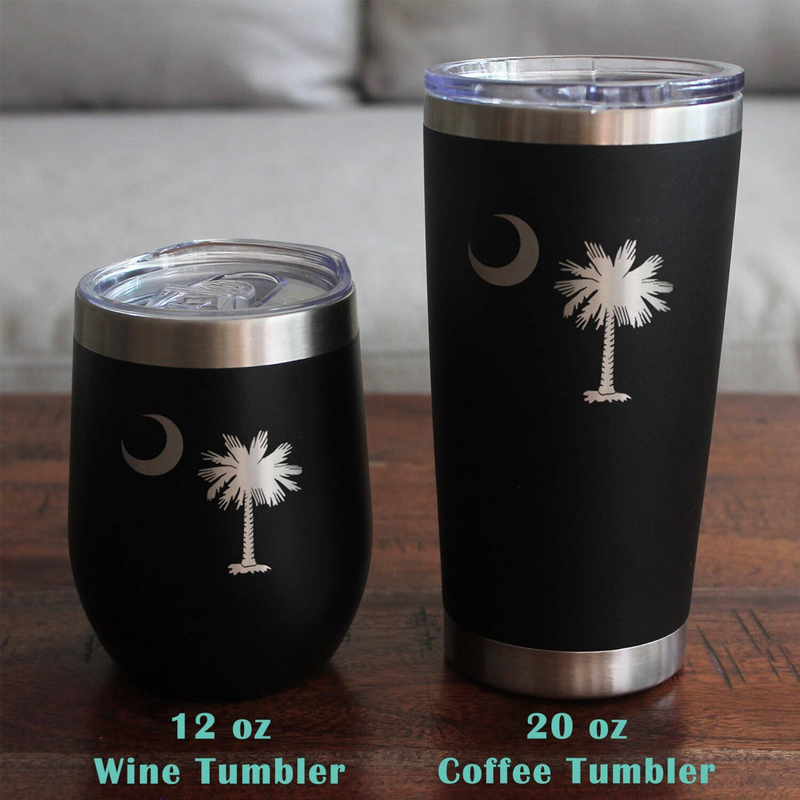 Black stemless wine tumbler with metal lid and etched moon and palm tree design.