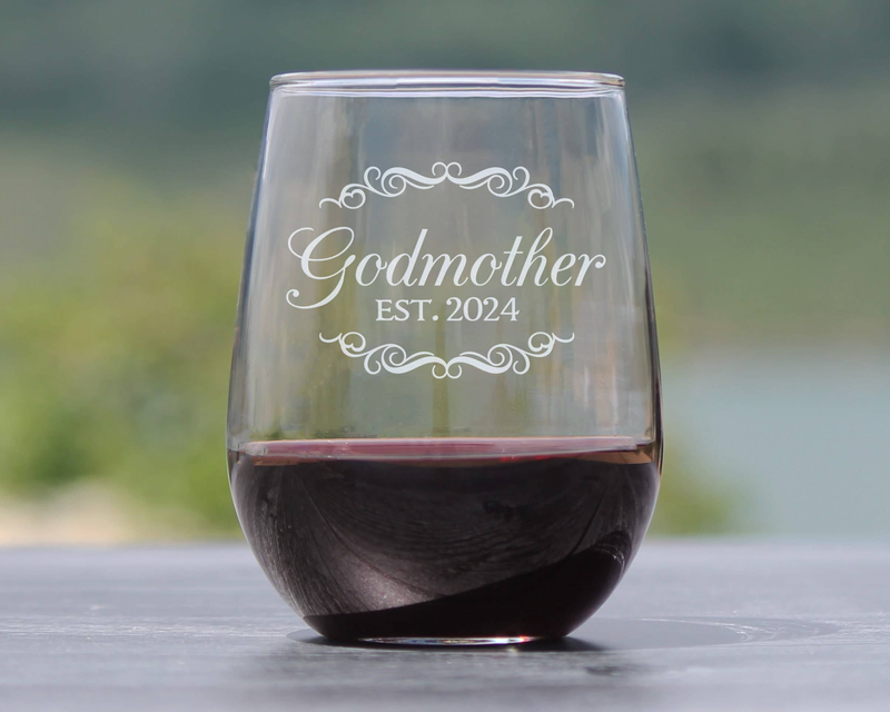 Stemless wine glass standing on a surface, etched “Godmother EST. 2024”